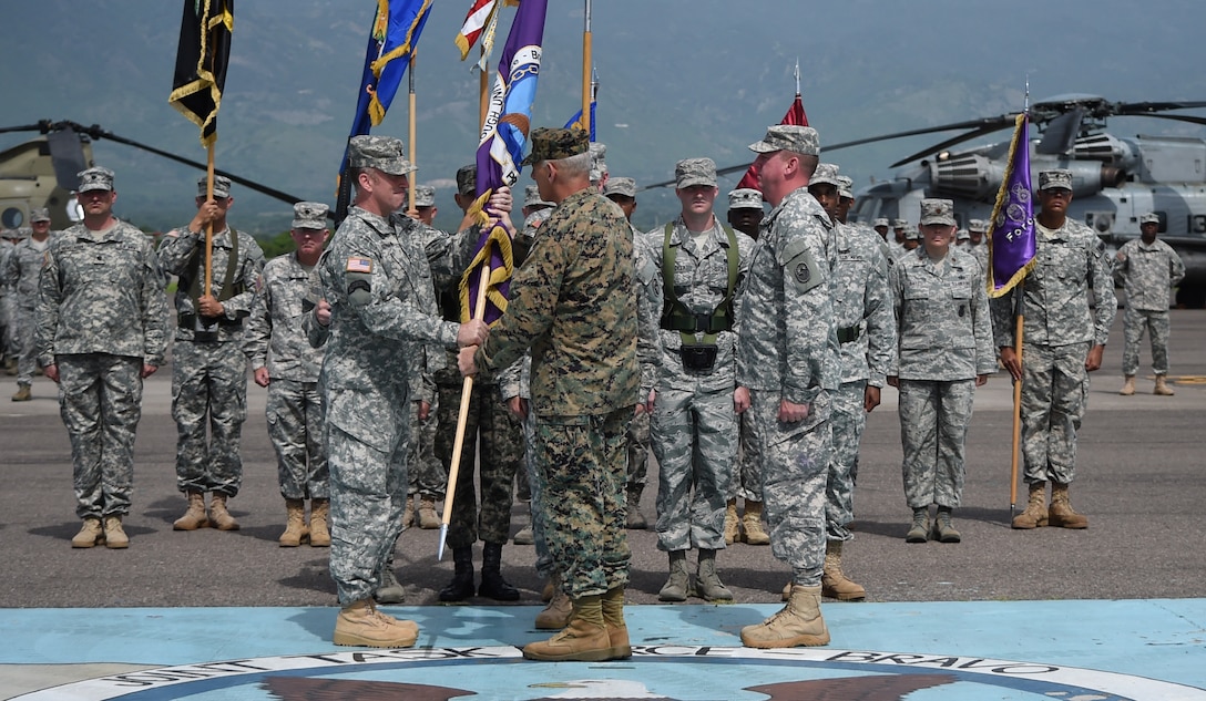 Gen. John Kelly, U.S. Southern Command commander, presents Col. Robert Harman, Joint Task Force – Bravo incoming commander, with the JTF – Bravo colors, signifying the transfer of authority over the Task Force from Col. Kirk Dorr, JTF – Bravo outgoing commander, to Harman June 30, 2015, at Soto Cano Air Base, Honduras. JTF – Bravo provides a forward presence for U.S. Southern Command in Central America in order to enhance regional security, stability and cooperation. (U.S. Air Force photo by Martin Chahin)