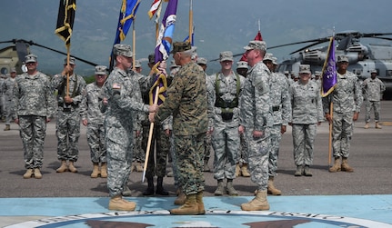 Gen. John Kelly, U.S. Southern Command commander, presents Col. Robert Harman, Joint Task Force – Bravo incoming commander, with the JTF – Bravo colors, signifying the transfer of authority over the Task Force from Col. Kirk Dorr, JTF – Bravo outgoing commander, to Harman June 30, 2015, at Soto Cano Air Base, Honduras. JTF – Bravo provides a forward presence for U.S. Southern Command in Central America in order to enhance regional security, stability and cooperation. (U.S. Air Force photo by Martin Chahin)