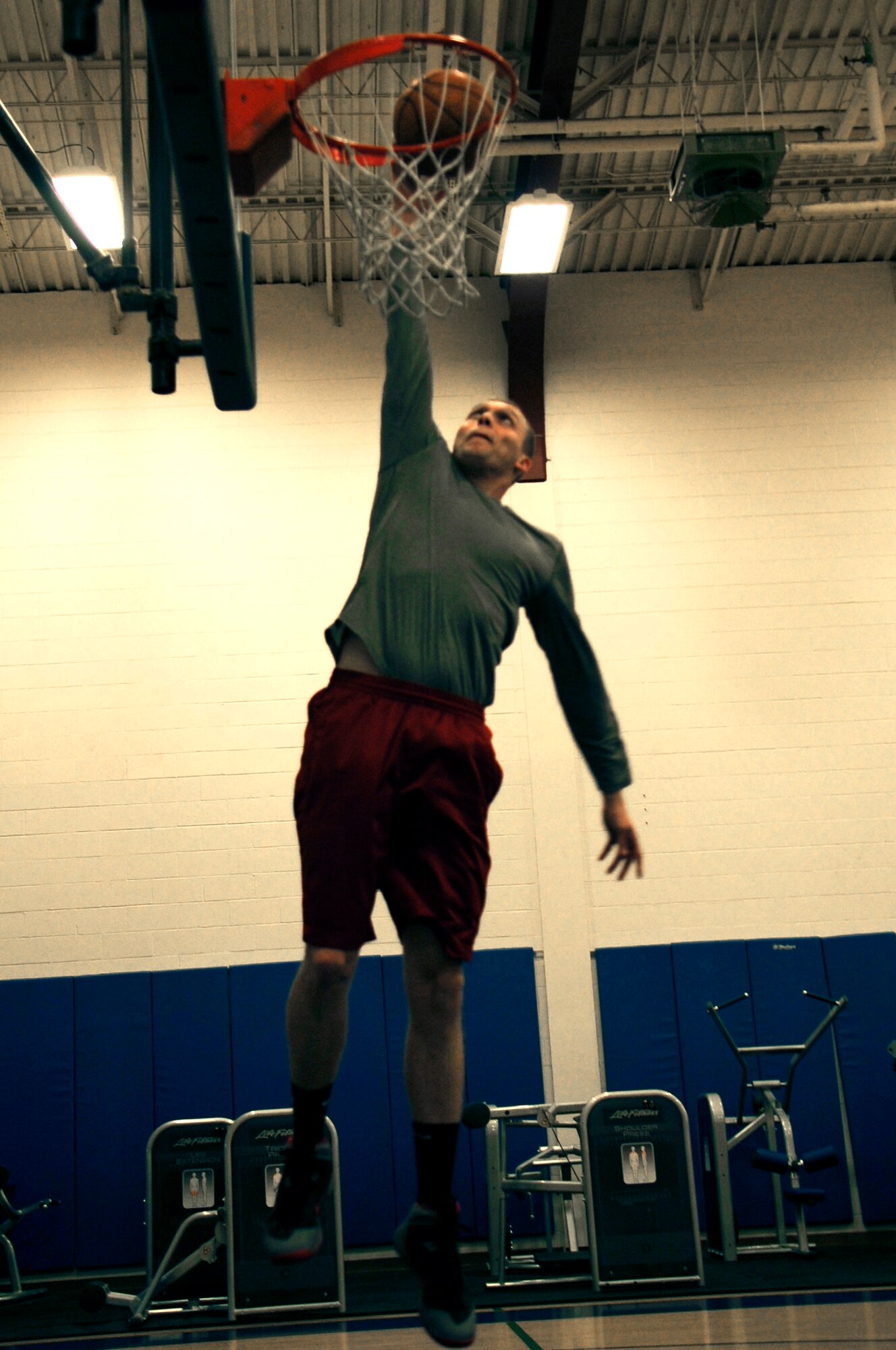 Senior Airman Tyler Cerney, 544th Intelligence, Surveillance and Reconnaissance Group, detachment 1, intelligence analyst, dunks a basketball, June 29, 2015, Vandenberg Air Force Base, Calif. Although being a Unit Fitness Program Monitor, and trained Physical Training Leader, can be demanding, Cerney not only accepts the responsibility – he relishes it. (U.S. Air Force photo by Senior Airman Shane Phipps/Released)