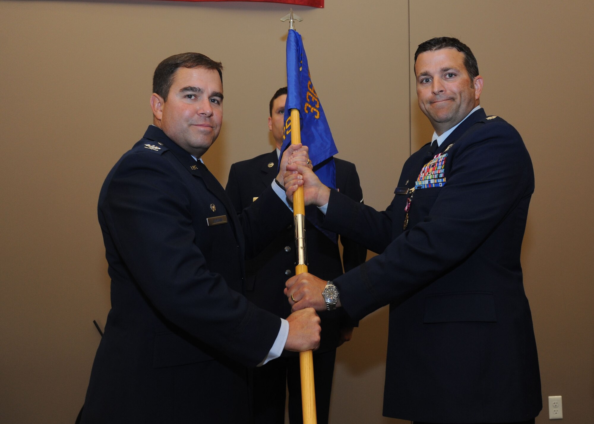 Col. Jonathan Duncan, 336th Training Group commander, takes the 66th Training Squadron guidon from Lt. Col. Jason Chandler, former 66th TRS commander, during the 66th TRS change of command ceremony June 30, 2015, at Fairchild Air Force Base, Wash. The change of command ceremony is an official, formal and brief ceremony that is the military’s way of bestowing command responsibility of a unit from one officer to another. (U.S. Air Force photo/Senior Airman Sam Fogleman)