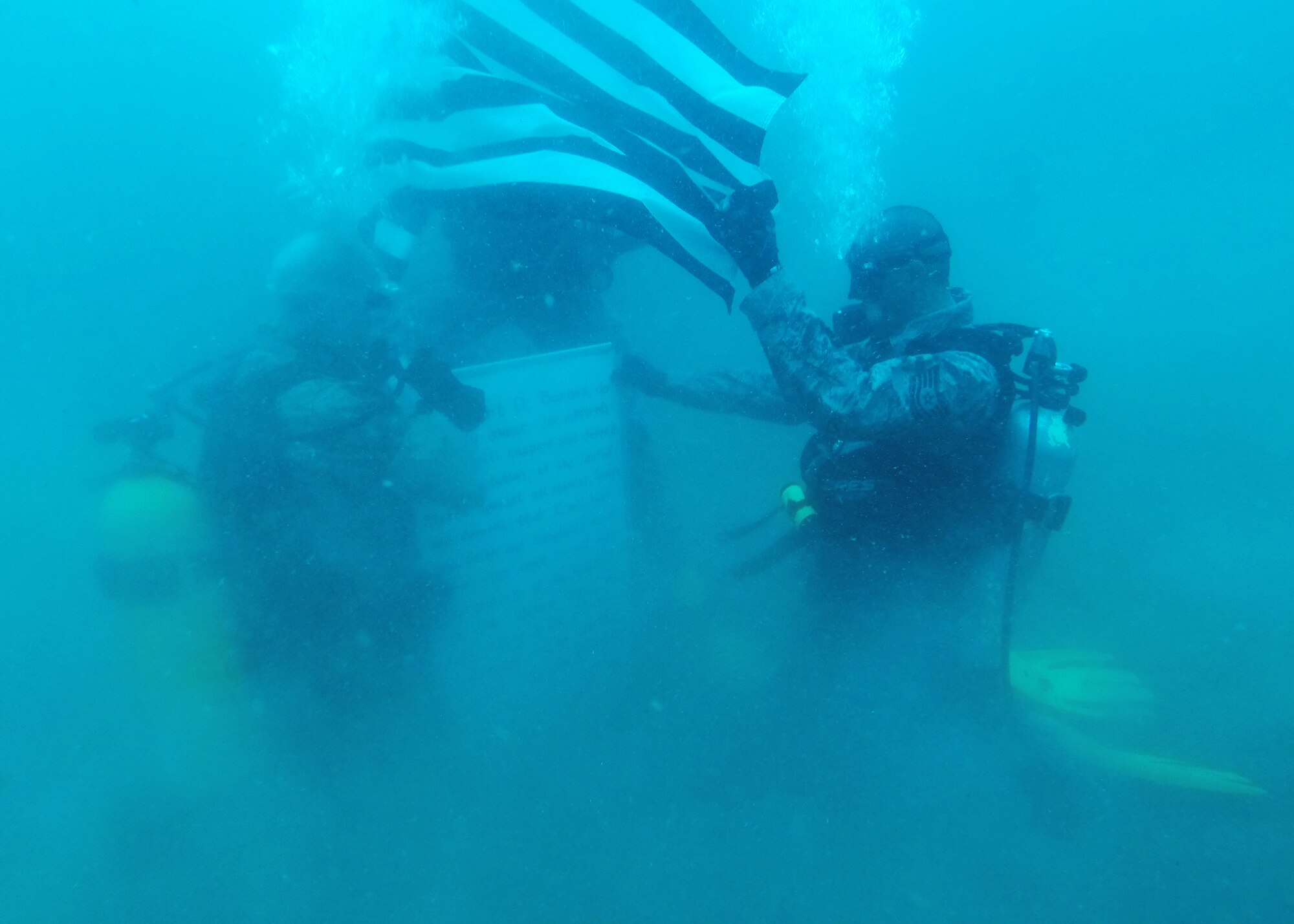 Jon Graydon, 1st Air Force (Air Forces Northern) civil support planner at Tyndall and an U.S. Marine Reserve lieutenant colonel (left), and Tech. Sgt. Robert Barnes, 325th Communications Squadron quality assurance NCO in charge, prepare for a re-enlistment ceremony under 70 feet of water June 26. Barnes needed an officer who was scuba certified to swear him in so he asked Graydon to be the re-enlistment officer. (U.S. Air Force photo by Airman 1st Class Sergio A. Gamboa/Released)