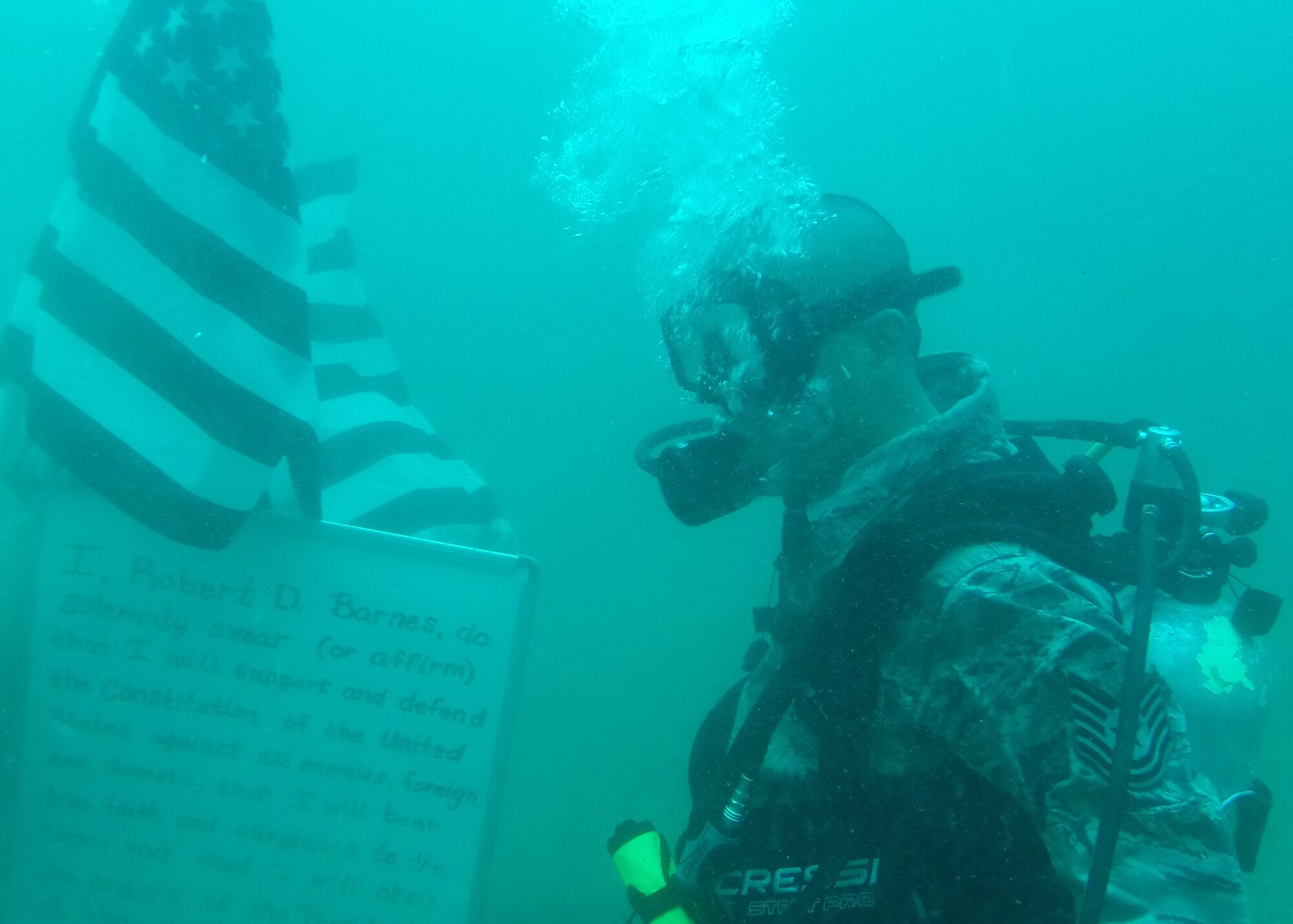 Technical Sgt. Robert Barnes, 325th Communications Squadron quality assurance NCO in charge, prepares to take the Air Force Oath of Enlistment June 26. His re-enlistment was 70 feet under water. (U.S. Air Force photo by Airman 1st Class Sergio A. Gamboa/Released) 