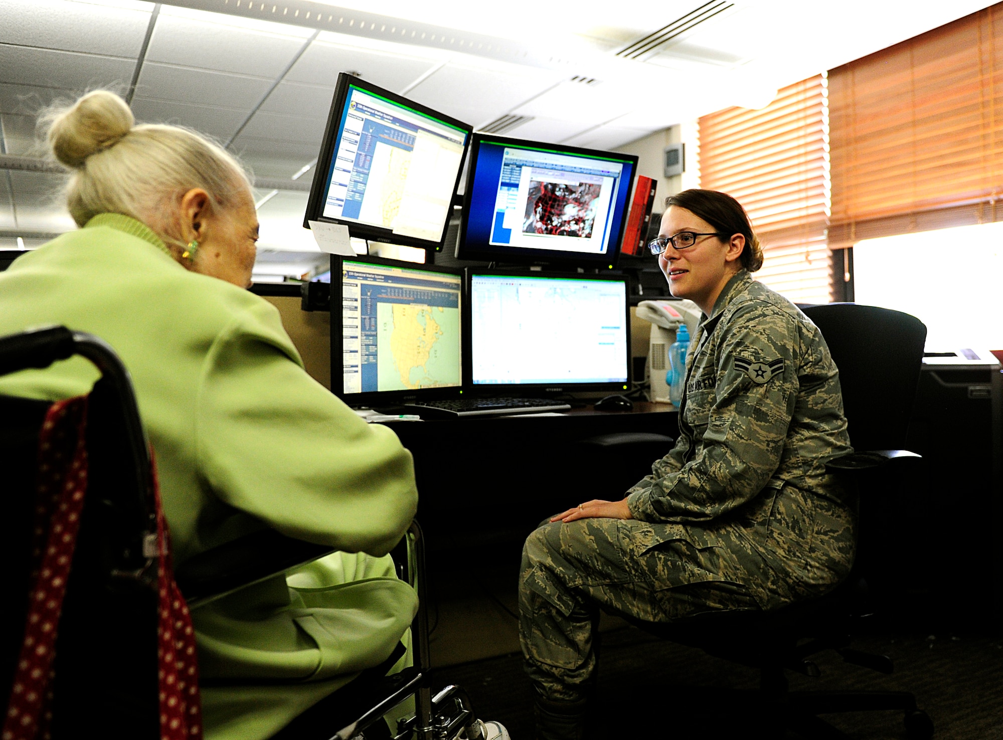 Airman 1st Class Emily Eason, 15th Operational Weather Squadron, shows Norma Cadena the tools a weather forecaster uses today at Scott Air Force Base, Ill., June 26, 2015. Cadena visited Scott with the help of Sisters of Saint Mary Health Hospice and Home Health Foundation “Memories that Last” program. She has terminal cancer and her last wish was to see what it would be like to be a weather forecaster today.  (U.S. Air Force photo/Staff Sgt. Stephenie Wade)