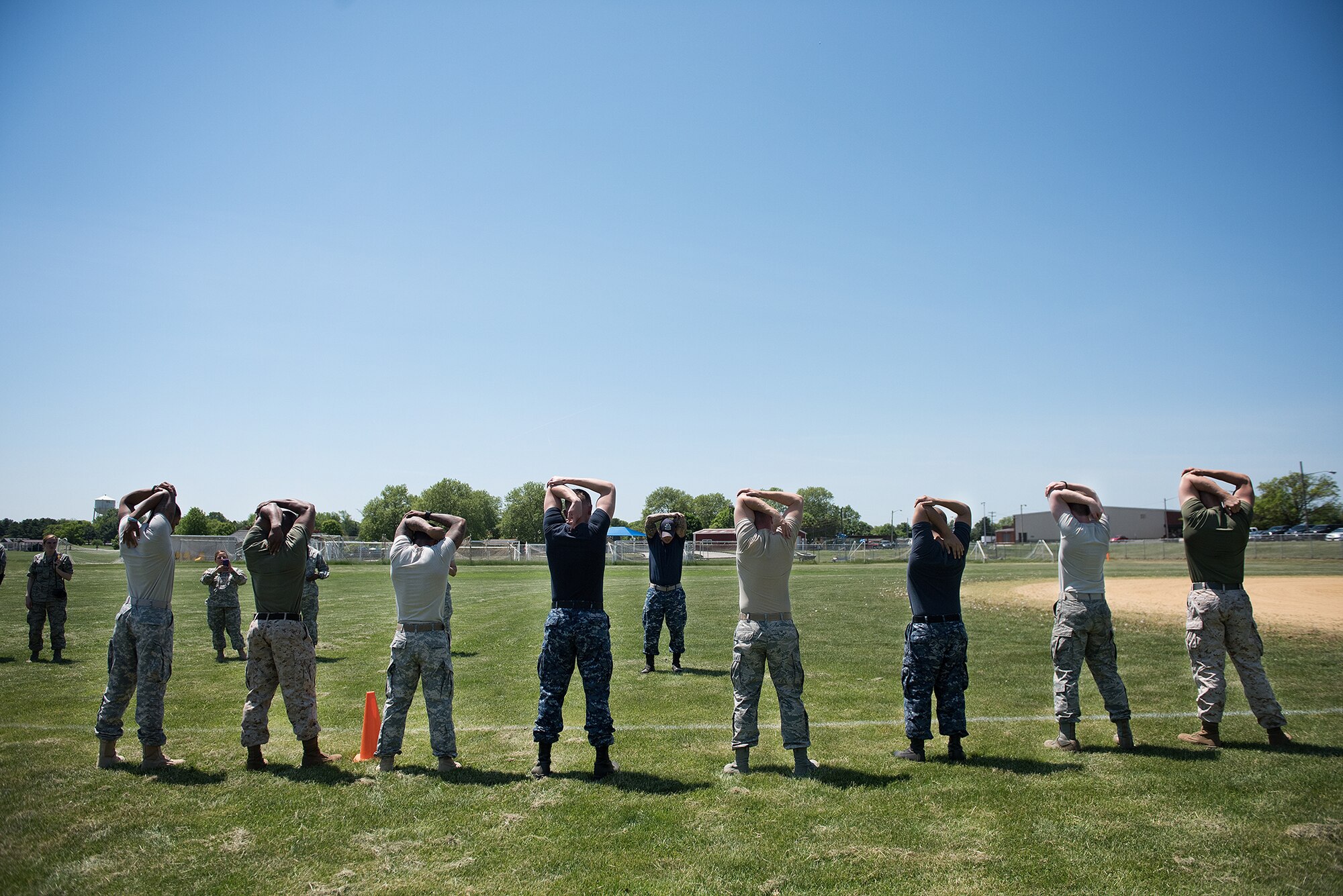 Competitors in the Joint Base Service Member of the Year Competition stretch before an obstacle course May 14, 2015 at Joint Base McGuire-Dix-Lakehurst N.J. This was the first annual competition and featured eight competitors, two each from the U.S. Army, Marines Corps, Navy and Air Force. (U.S. Air Force photo by Staff Sgt. Katherine Tereyama)