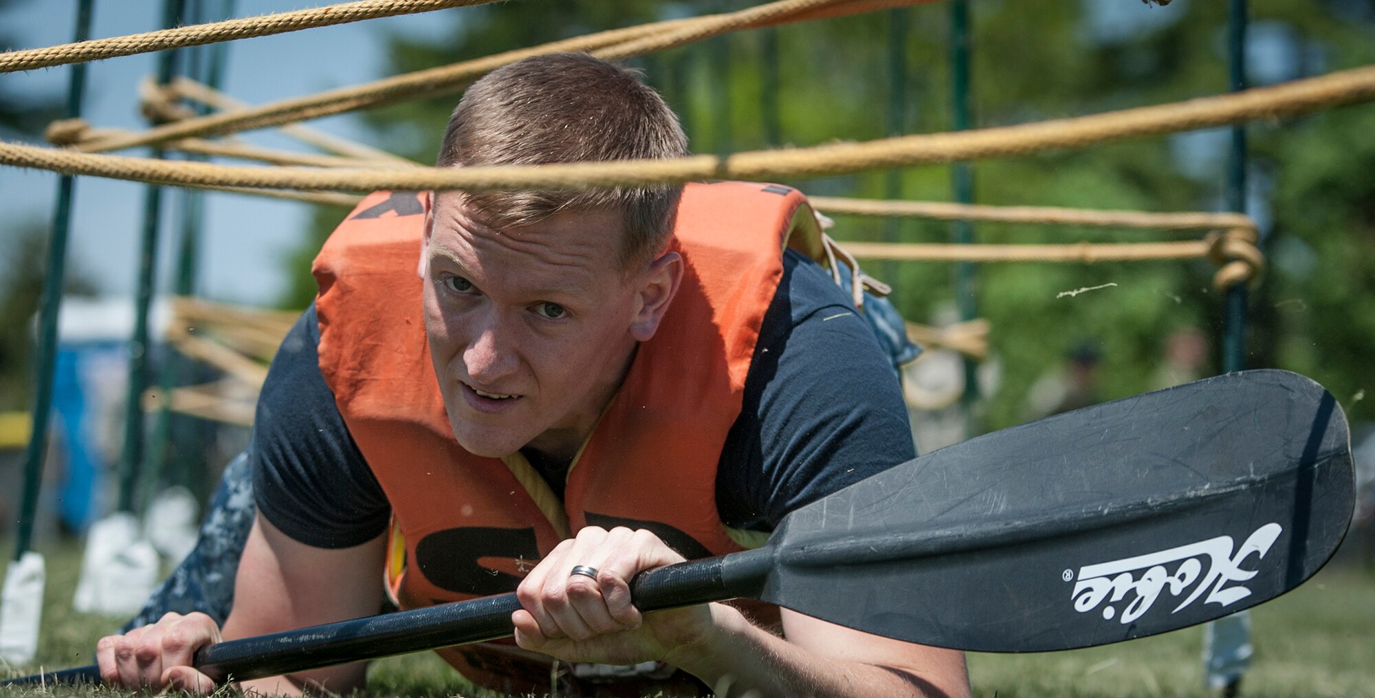 U.S. Navy Petty Officer 2nd Class Shane Peterman, Lakehurst Naval Health Clinic, low crawls during the obstacle course portion of the Joint Base Service Member of the Year Competition May 14, 2015 at Joint Base McGuire-Dix-Lakehurst N.J. This was the first annual competition and featured seven events including a marksmanship qualification, first aid, a 100-point written examination, board appearance, urban orienteering, multi-service physical fitness test and an obstacle course. Foster won in the NCO category. (U.S. Air Force photo by Senior Airman Scott Saldukas)