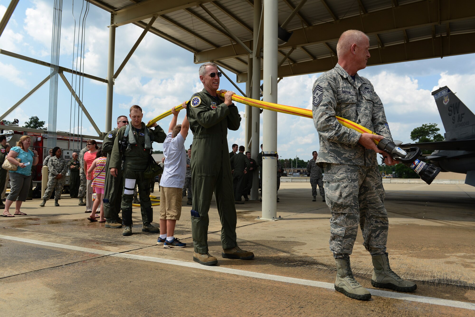 U.S. Air Force Airmen and family members gather for the ceremonial water spraying after U.S. Air Force Maj. Gen. H. D. Polumbo Jr., Ninth Air Force commander, had his final flight at Shaw Air Force Base, S.C., June 26, 2015. Airmen, community leaders, family and friends greeted Polumbo after his fini-flight to thank him for his service and congratulate him on his retirement. (U.S. Air Force photo by Senior Airman Diana M. Cossaboom/Released)