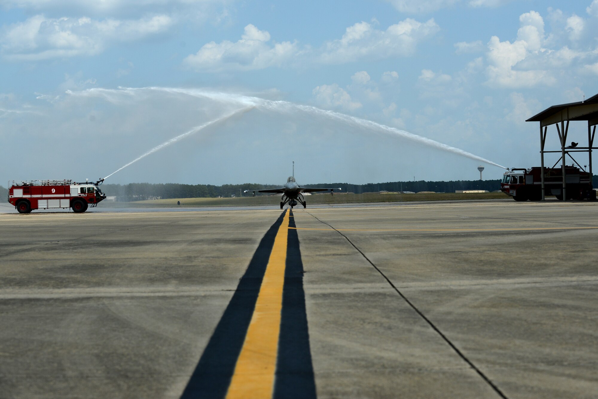 U.S. Air Force Maj. Gen. H. D. Polumbo Jr., Ninth Air Force commander, taxis his F-16CM Fighting Falcon through an archway of water after returning from his final flight at Shaw Air Force Base, S.C. June 26, 2015. Polumbo is scheduled to retire during the month of July after 34 years of military service. (U.S. Air Force photo by Senior Airman Diana M. Cossaboom/Released)