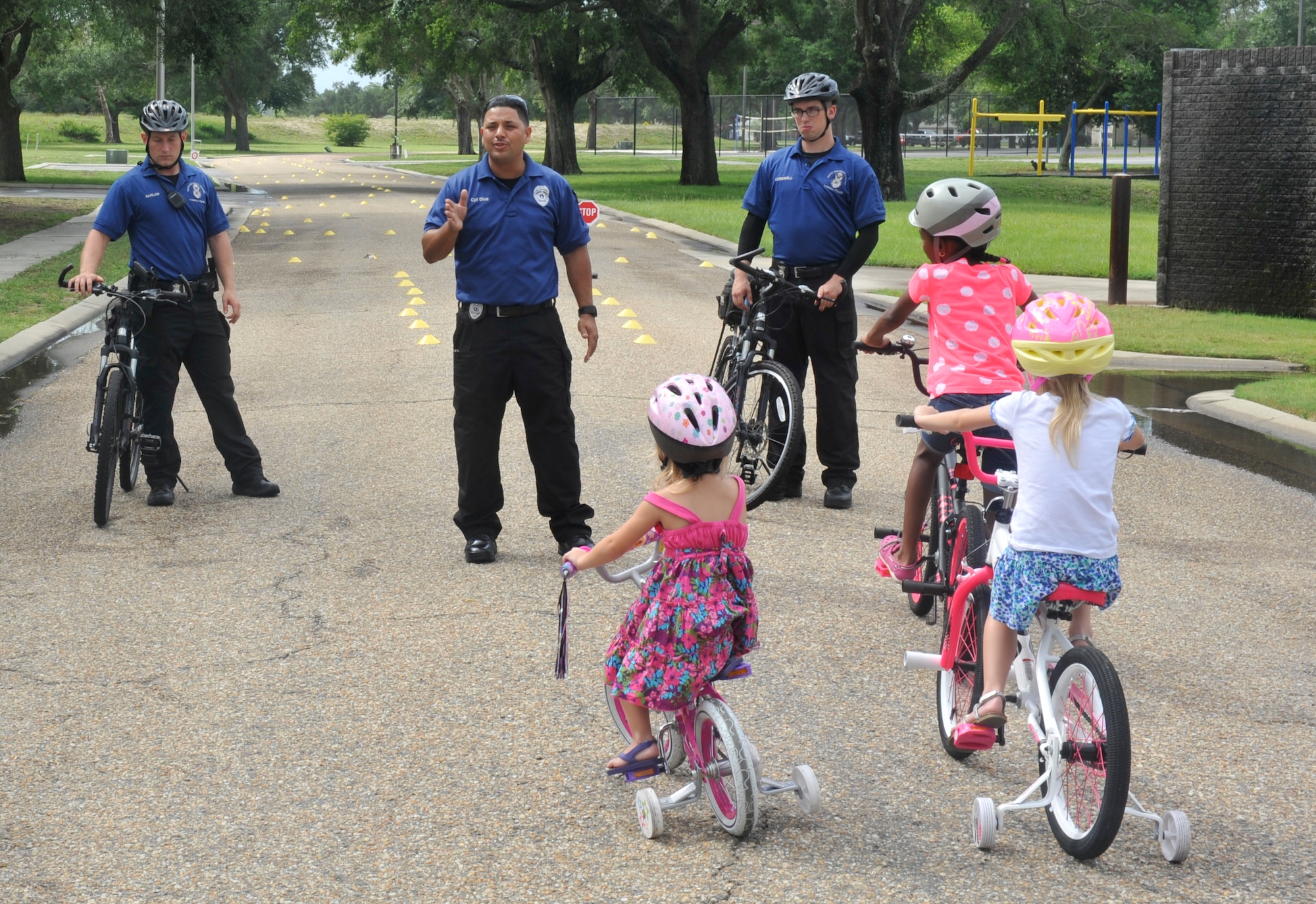 Corporal Juan Diaz, 325th Security Forces Squadron community police officer, teaches children about bike riding safety June 27 at the Belfour Beatty Community Center. The Community Police host the bicycle rodeo every year to improve relations between Tyndall families and security forces and to ensure all children know proper bike riding safety precautions. (U.S. Air Force photo by Airman 1st Class Cody R. Miller/Released)    