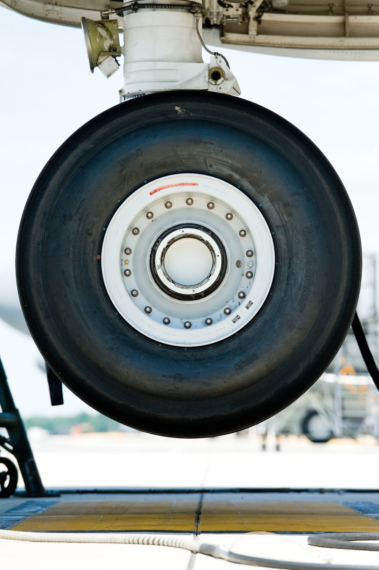 The four nose landing gear tires of a C-5M Super Galaxy hang over the parking spot June 25, 2015, on Dover Air Force Base, Del. The aircraft was jacked to perform troubleshooting procedures and operational checks after corrective maintenance actions were taken. (U.S. Air Force photo/Roland Balik)