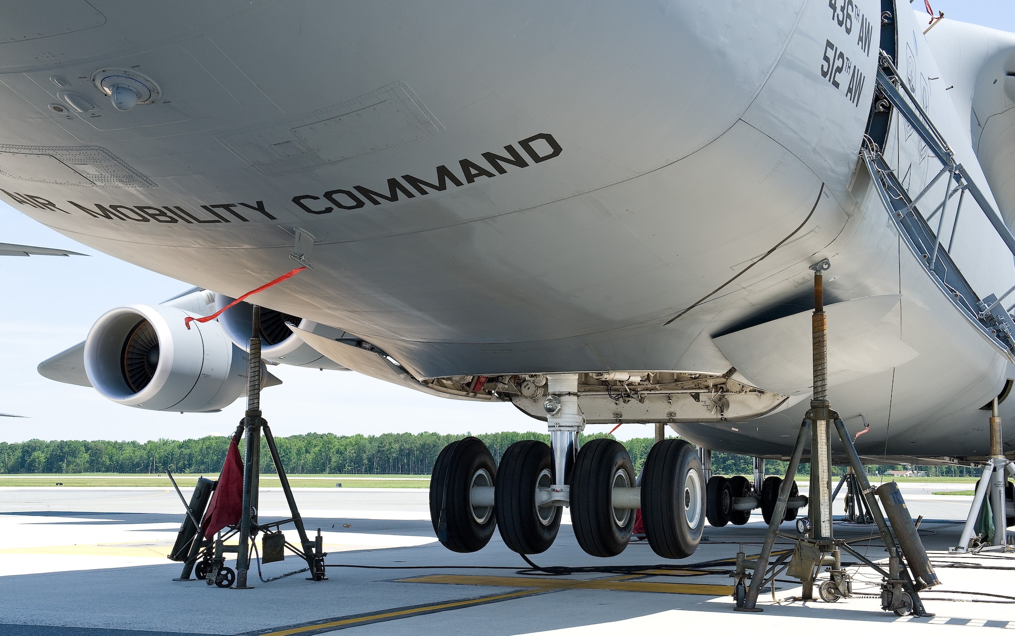 Two 30-ton tripod aircraft jacks hold up the nose section of a C-5M Super Galaxy June 25, 2015, on Dover Air Force Base, Del. The nose and main landing gear tires are raised between 6 and 14 inches, depending on the type of gear maintenance actions and troubleshooting procedures are required. (U.S. Air Force photo/Roland Balik)