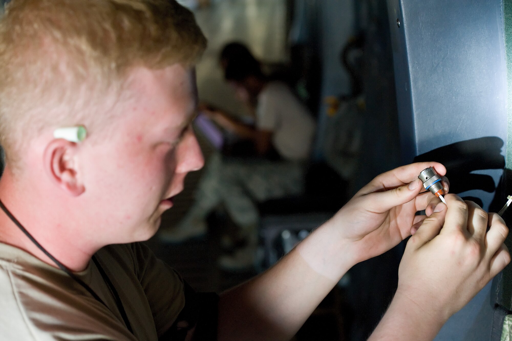 Airman 1st Class Christopher Kent, 436th Aircraft Maintenance Squadron electric and environmental technician, replaces a cannon plug in the cargo compartment of a C-5M Super Galaxy June 25, 2015, on Dover Air Force Base, Del. Kent removed and replaced the faulty cannon plug on one of the right aft main landing gear control solenoids. (U.S. Air Force photo/Roland Balik)