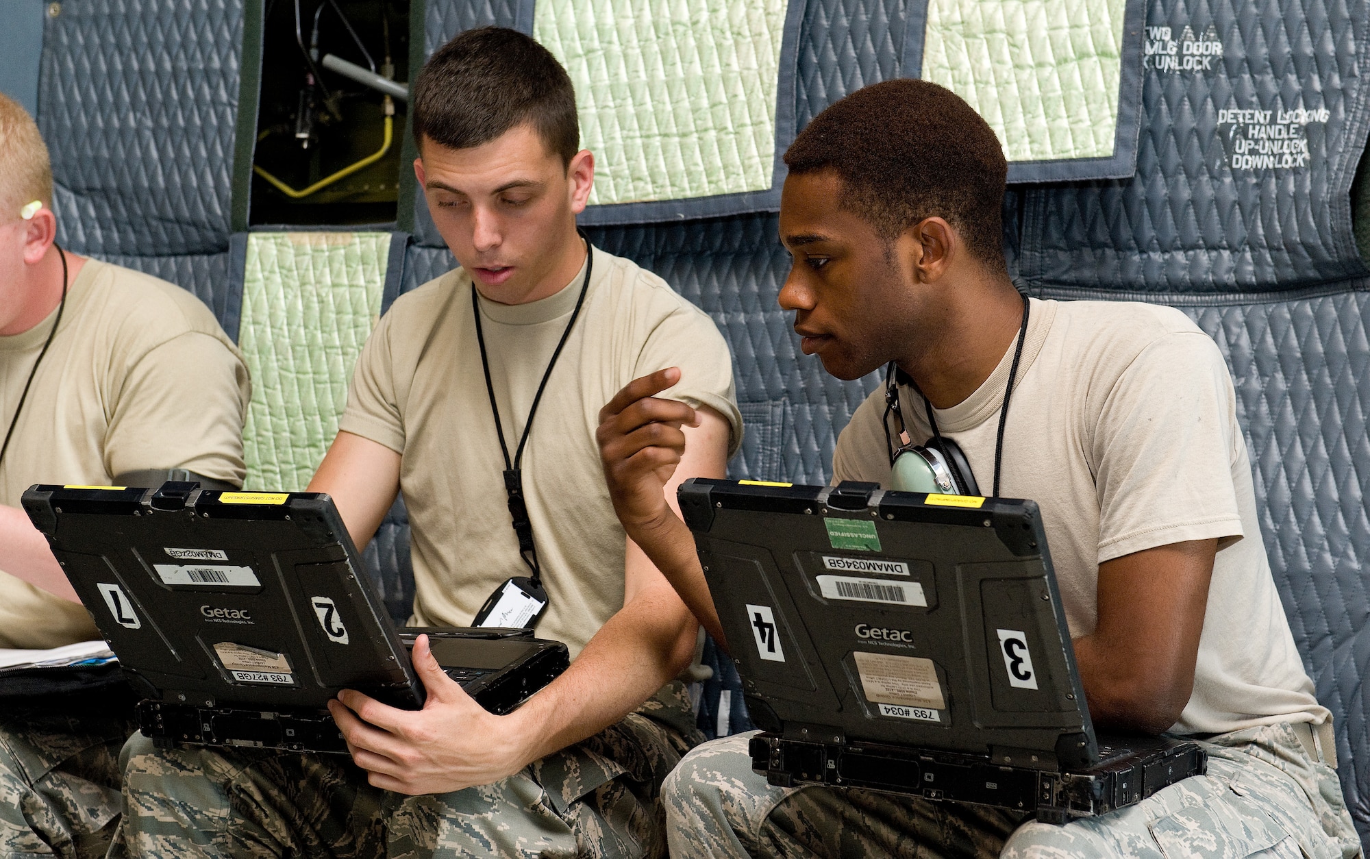 Airman 1st Class Raymond Meyers, left, and Staff Sgt. Demarious Beard, right, both 436th Aircraft Maintenance Squadron electric and environmental technicians, read C-5M technical orders on a laptop in the cargo compartment of a Super Galaxy June 25, 2015, on Dover Air Force Base, Del. Meyers and Beard were part of a maintenance team assigned to troubleshoot and repair a main landing gear discrepancy. (U.S. Air Force photo/Roland Balik)