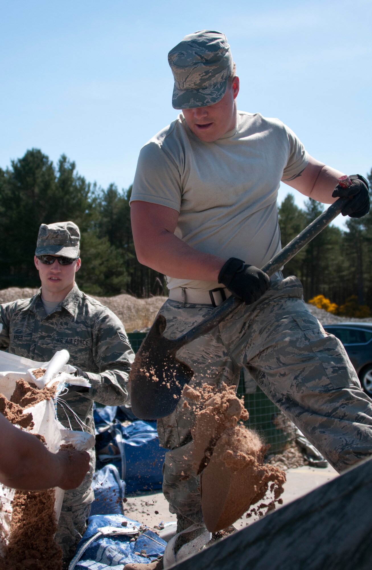 U.S. Air Force Senior Airman Connor Larkin, a power production specialist with the 128th Air Refueling Wing, shovels sand into a cement mixer at Kinloss Barracks in Morayshire, Scotland, United Kingdom, in support of Exercise Flying Rose June 12, 2015. The cement was being used to fill the concrete pads at the Kinloss Barracks Single Living Accommodation. The 128th Air Refueling Wing Civil Engineering Squadron Airmen were building the concrete pads in support of Exercise Flying Rose, an exchange exercise between the U.S. Air National Guard and British Army, where forces deploy to one another’s countries and work to complete construction-related tasks. (U.S. Air National Guard photo by Airman 1st Class Morgan R. Lipinski/Released)