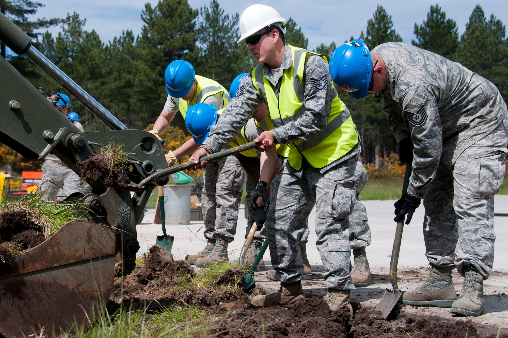 U.S. Air Force Airmen with the Civil Engineering Squadron of 128th Air Refueling Wing, excavate dirt at a construction site June 10, 2015, at Kinloss Barracks in Morayshire, Scotland, United Kingdom, in support of Exercise Flying Rose. The construction site was being prepared as the foundation for a troop shelter set to be used by the British Army for Kinloss Barracks’ air support training. The 128 ARW CE Airmen were participating in Exercise Flying Rose, an exchange exercise between the U.S. Air National Guard and British Army where forces deploy to one another’s countries and work to complete construction-related tasks. (U.S. Air National Guard photo by Airman 1st Class Morgan R. Lipinski/Released)