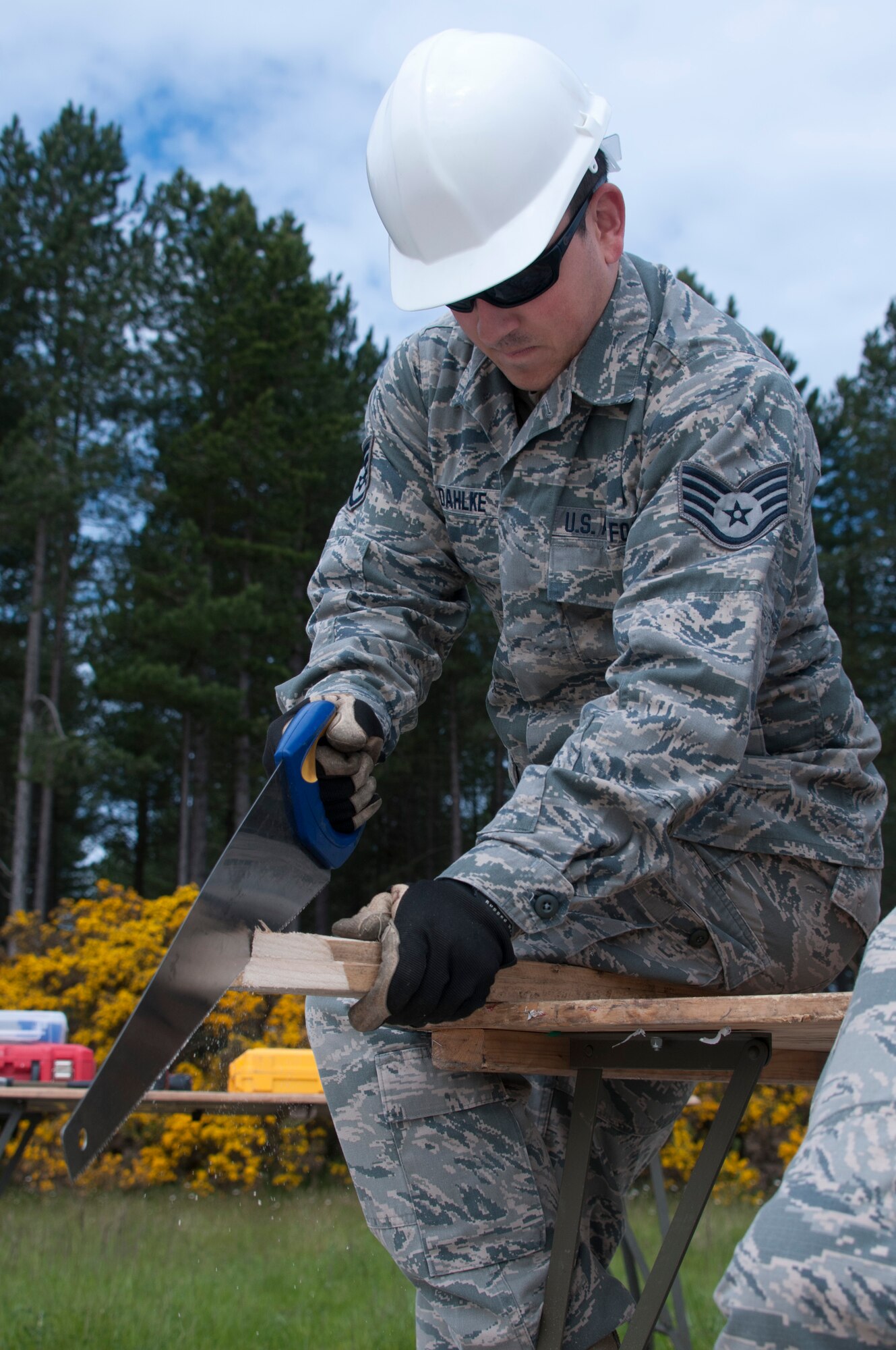 U.S. Air Force Staff Sgt. Daniel Dahlke, a structural specialist Civil Engineering Squadron of the 128th Air Refueling Wing, uses a handsaw to cut a section of wood to the correct size June 10, 2015, at Kinloss Barracks in Morayshire, Scotland, United Kingdom, in support of Exercise Flying Rose. Exercise Flying Rose is an exchange exercise between the U.S. Air National Guard and British Army, where forces deploy to one another’s countries and work to complete construction-related tasks. (U.S. Air National Guard photo by Airman 1st Class Morgan R. Lipinski/Released)