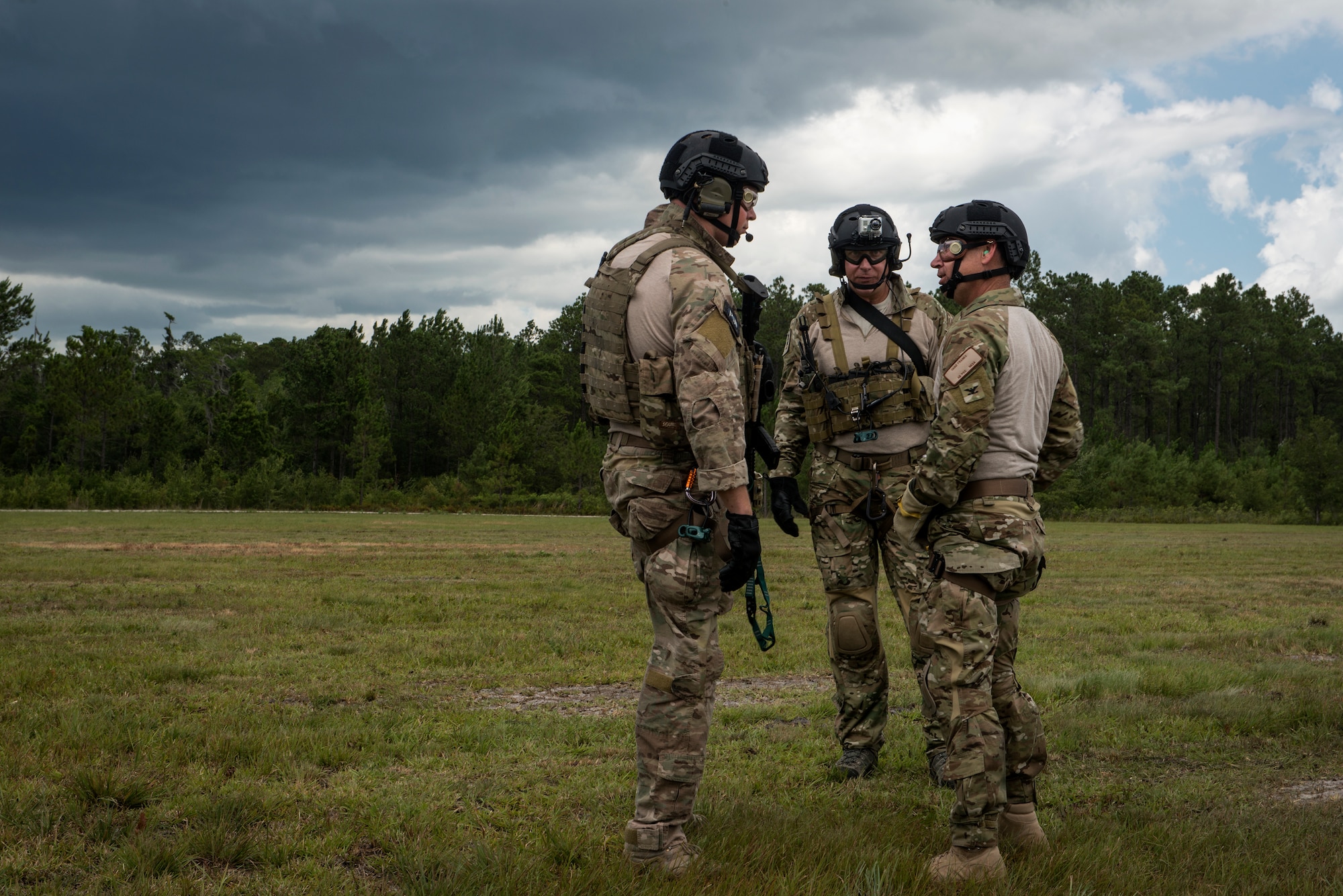 U.S. Air Force Col. Chad Franks, right, 23d Wing commander, speaks with pararescuemen from the 38th Rescue Squadron after rappelling from an HH-60G Pave Hawk during his fini-flight June 26, 2015, on Grand Bay Bombing and Gunnery Range at Moody Air Force Base, Ga. During his fini-flight, Franks flew both the HC-130J Combat King II and the HH-60G Pave Hawk. (U.S. Air Force photo by Senior Airman Ryan Callaghan/Released)
