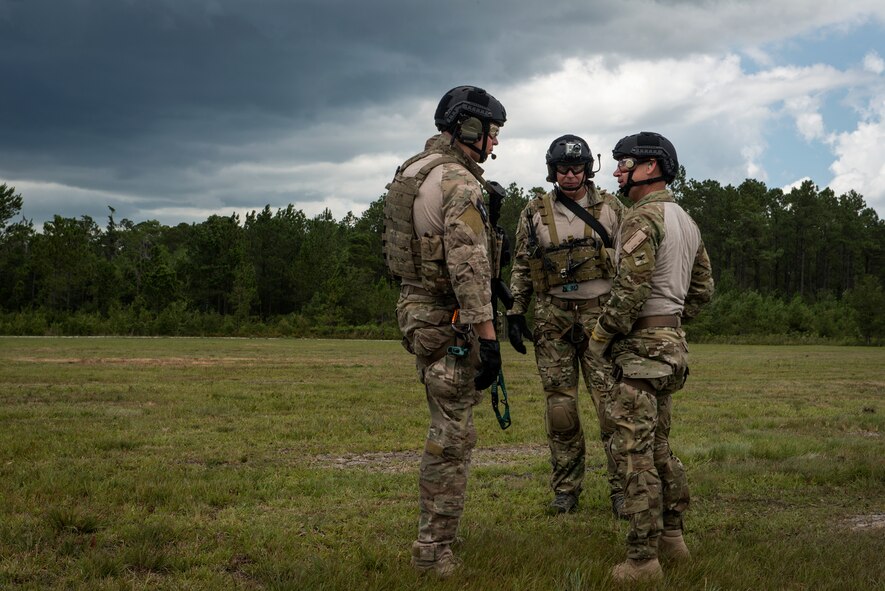 U.S. Air Force Col. Chad Franks, right, 23d Wing commander, speaks with pararescuemen from the 38th Rescue Squadron after rappelling from an HH-60G Pave Hawk during his fini-flight June 26, 2015, on Grand Bay Bombing and Gunnery Range at Moody Air Force Base, Ga. During his fini-flight, Franks flew both the HC-130J Combat King II and the HH-60G Pave Hawk. (U.S. Air Force photo by Senior Airman Ryan Callaghan/Released)
