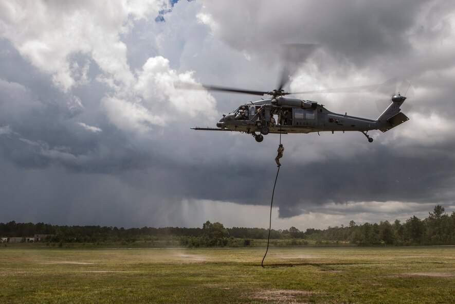 U.S. Air Force Col. Chad Franks, 23d Wing commander, rappels from an HH-60G Pave Hawk during his fini-flight June 26, 2015, on Grand Bay Bombing and Gunnery Range at Moody Air Force Base, Ga. Moments after the rappel, a storm rolled in and forced the aircraft to land. (U.S. Air Force photo by Senior Airman Ryan Callaghan/Released)

