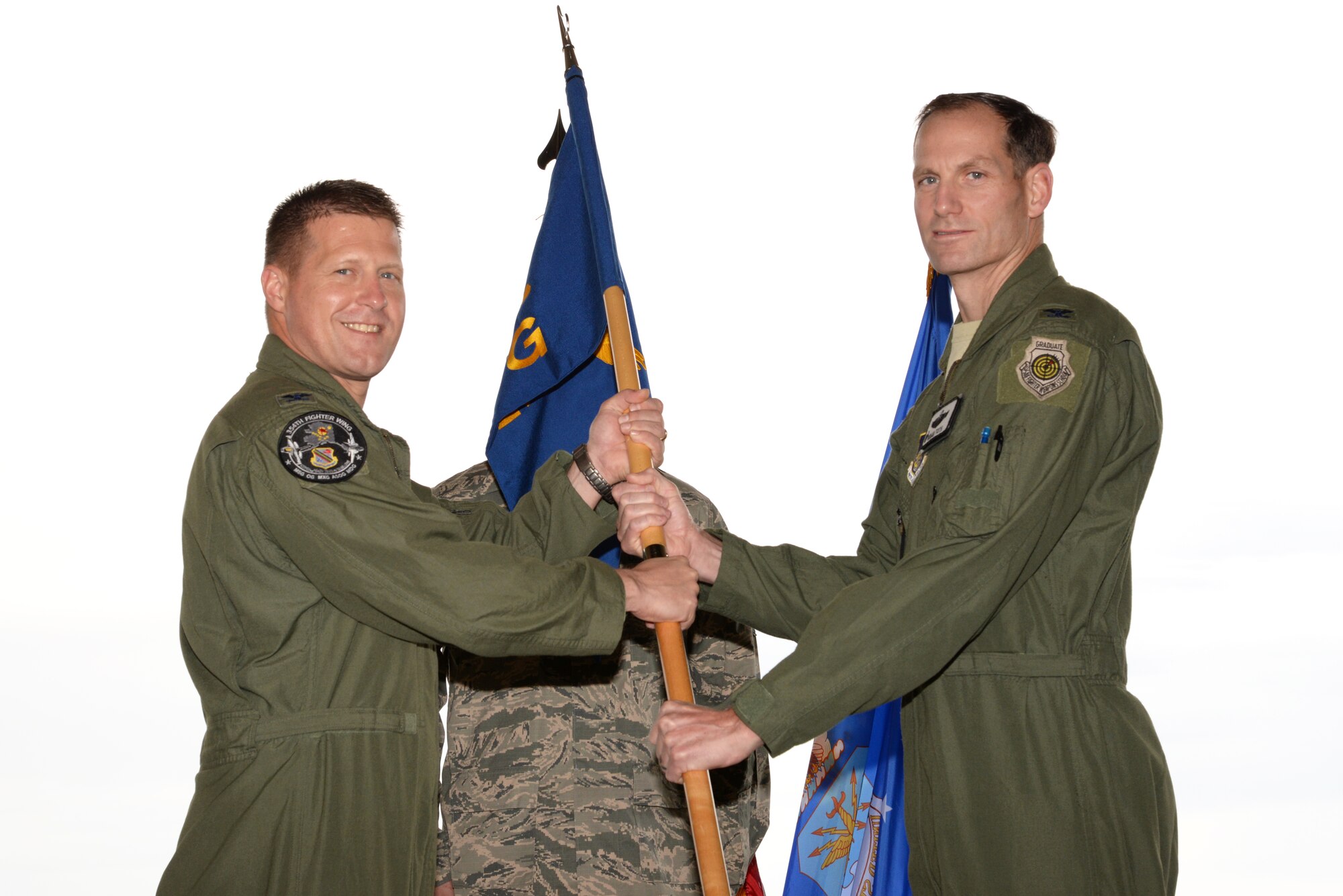 Col. Michael Winkler, the 354th Fighter Wing commander, passes command of the 354th Operations Group to Col. Brian Toth, during the change of command ceremony June 30, 2015, Eielson Air Force Base, Alaska. Col. Stephen Platt, the outgoing group commander, will retire. (U.S. Air Force photo by Staff Sgt. Kirsten Wicker/Released) 