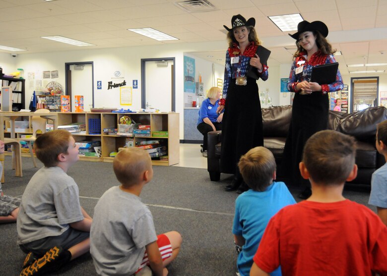 Rachael Braaten, 2015 Girl of the West, 9left) and Allison Mitchell, 2015 Aide to the Girl of the West, speak to School Age Program students about the Pikes peak or Bust Rodeo Monday, June 29,2015 at Schriever Air Force Base, Colorado. This year marks the 75th anniversary for the Pikes Peak or Bust Rodeo which will take place July 8-11. (U.S. Air Force photo/ Staff Sgt. Debbie Lockhart)