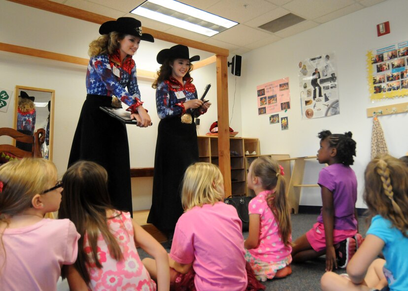 Rachael Braaten, 2015 Girl of the West, 9left) and Allison Mitchell, 2015 Aide to the Girl of the West, speak to School Age Program students about the Pikes peak or Bust Rodeo Monday, June 29,2015 at Schriever Air Force Base, Colorado. This year marks the 75th anniversary for the Pikes Peak or Bust Rodeo which will take place July 8-11. (U.S. Air Force photo/ Staff Sgt. Debbie Lockhart)