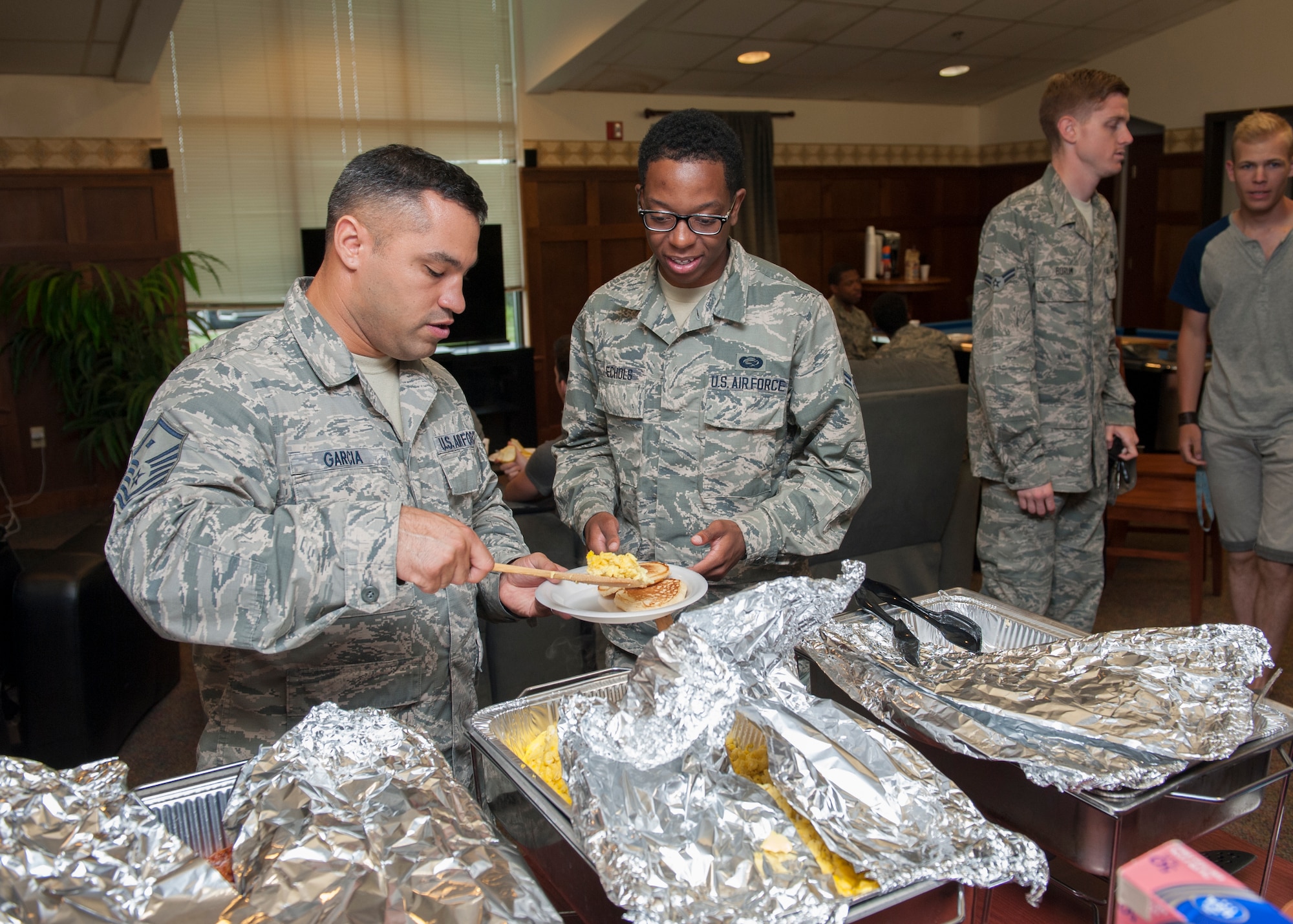 Master Sgt. William Garcia, 436th Aircraft Maintenance Squadron first sergeant, serves breakfast to Airman 1st Class Darren Echols, 436th Force Support Squadron personnelist , at a dorm dinner June 25, 2015, at Dover Air Force Base, Del. The event was organized by the First Sergeant’s Council. (U.S. Air Force photo/Airman 1st Class Zachary Cacicia) 
