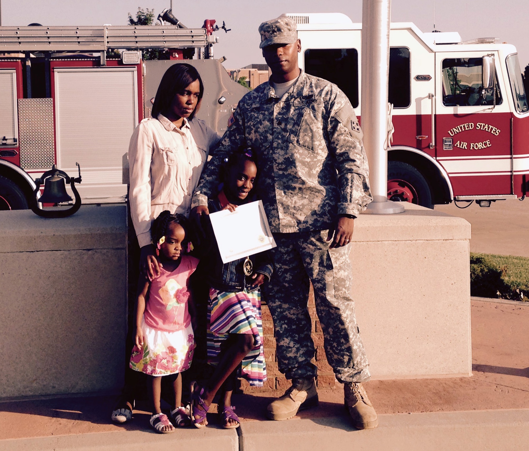 In a moment away from the spot light Sanyla Boyd is surrounded by sister Shaian, 3, mother Tranise and father, U.S. Army Sgt. Michael Boyd after receiving the inaugural 911 Award for Heroism by Peterson Air Force Base Fire Emergency Services on June 26, 2015. The award recognized her calm in the face of an emergency when her mother collapsed with chest pain May 14, 2015. Her quick action probably saved her mother’s life. (U.S. Air Force photo by Dave Smith)