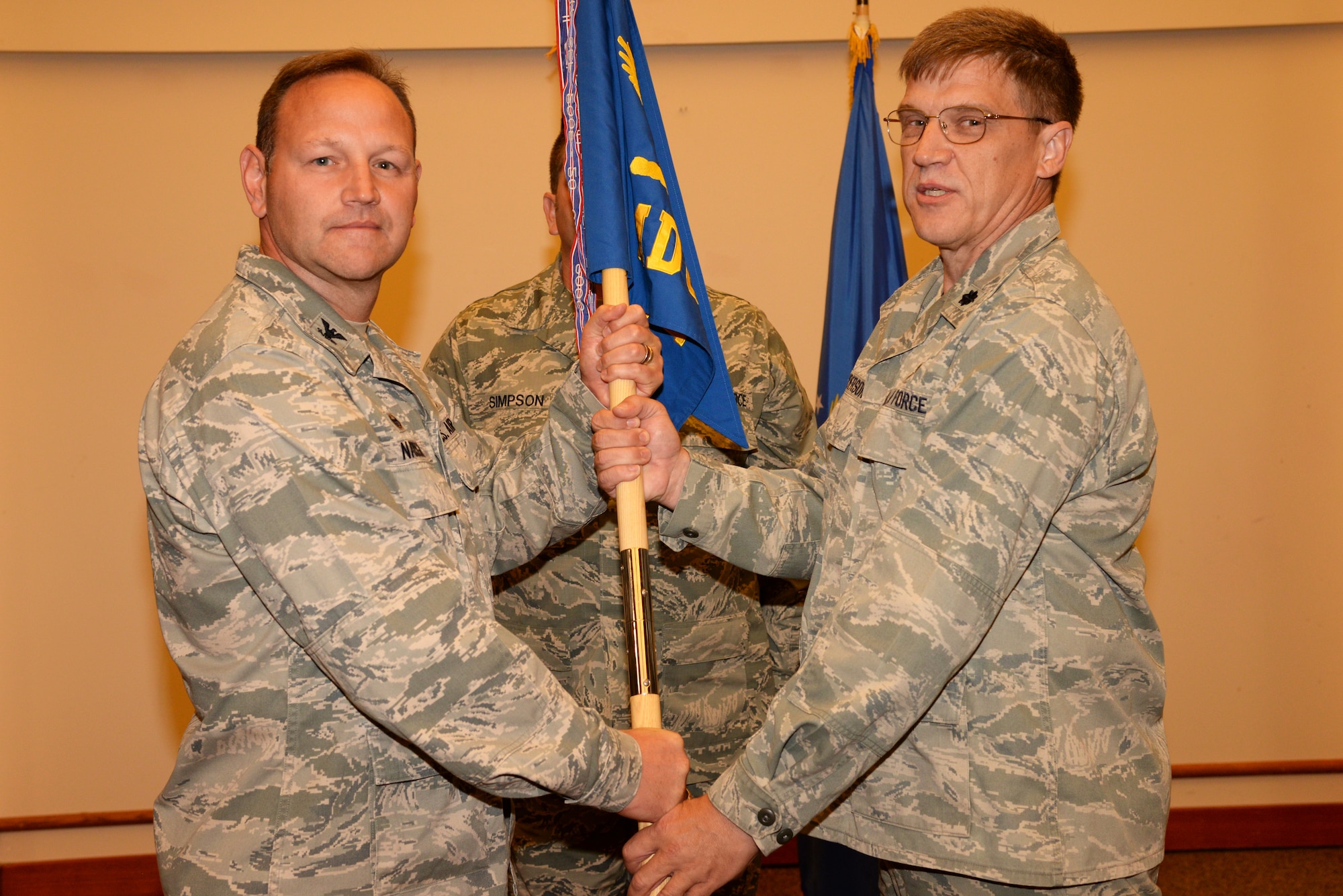Col. Joseph Narrigan, the 354th Medical Group commander, passes command of the 354th Medical Operations Squadron to Lt. Col. Mark Anderson, during the change of command ceremony June 29, 2015, Eielson Air Force Base, Alaska. Lt. Col. Mary Guest, the outgoing squadron commander, will move on to Eglin Air Force Base, Fla. (U.S. Air Force photo by Staff Sgt. Kirsten Wicker/Released)