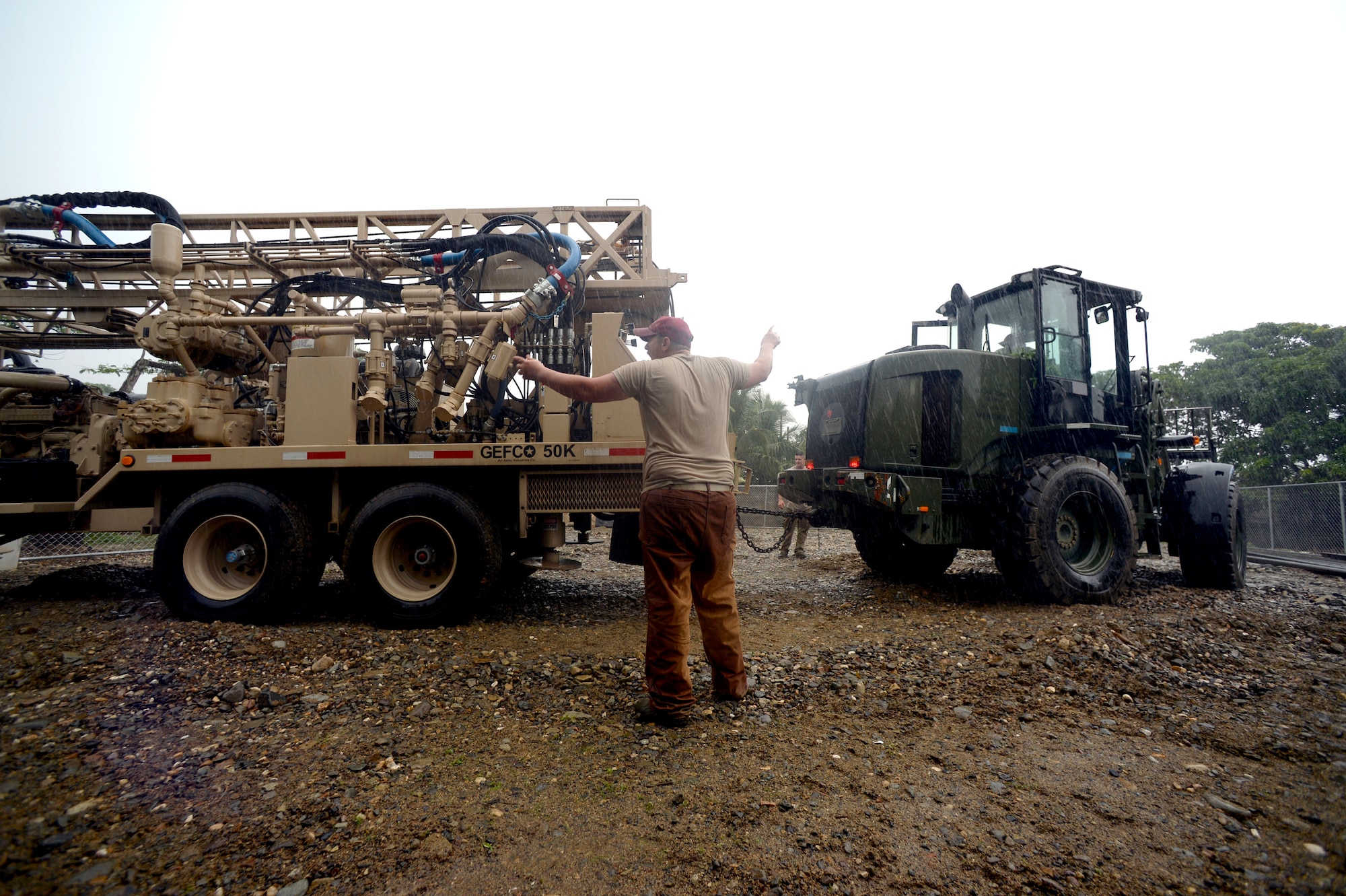 U.S. Air Force Senior Airman Kevin Conklin, 823rd Expeditionary RED HORSE Squadron pavements and construction equipment operator, helps direct vehicles at the Honduras Aguan well site near Trujillo, Honduras, June 25, 2015. The well-drilling team is setting up to dig a well to provide clean water to 6,000 residents in and around the area as part of the NEW HORIZONS Honduras 2015 training exercise. NEW HORIZONS was launched in the 1980s and is an annual joint humanitarian assistance exercise that U.S. Southern Command conducts with a partner nation in Central America, South America or the Caribbean. The exercise improves joint training readiness of U.S. and partner nation civil engineers, medical professionals and support personnel through humanitarian assistance activities. (U.S. Air Force photo by Capt. David J. Murphy/Released)