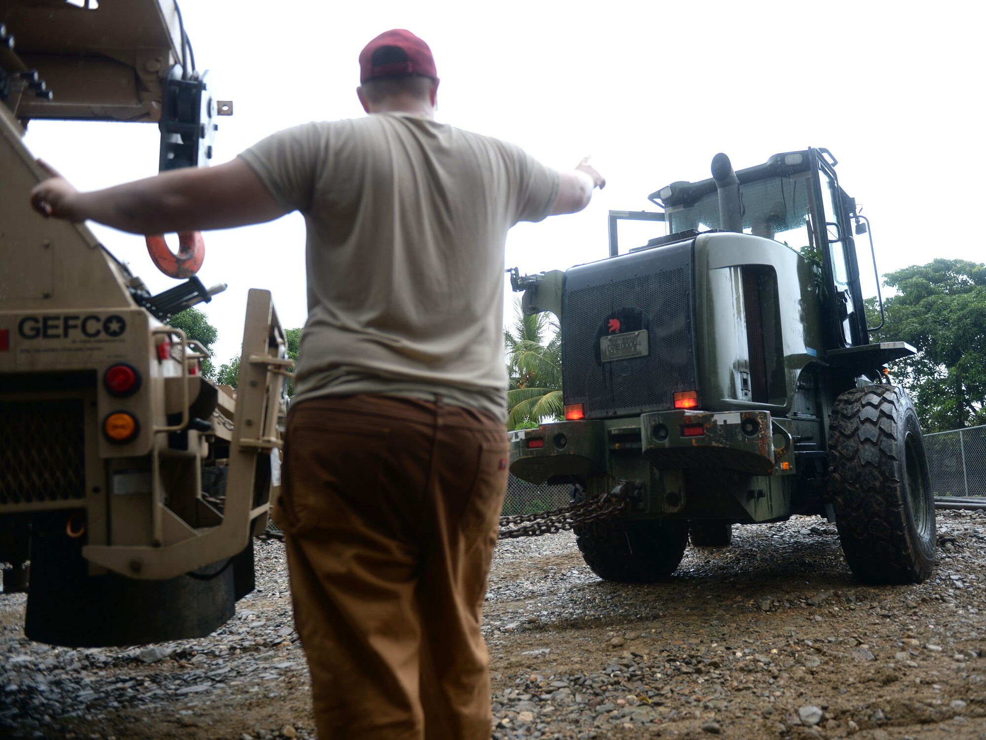 U.S. Air Force Senior Airman Kevin Conklin, 823rd Expeditionary RED HORSE Squadron pavements and construction equipment operator, helps direct vehicles at the Honduras Aguan well site near Trujillo, Honduras, June 25, 2015. The well-drilling team is setting up to dig a well to provide clean water to 6,000 residents in and around the area as part of the NEW HORIZONS Honduras 2015 training exercise. NEW HORIZONS was launched in the 1980s and is an annual joint humanitarian assistance exercise that U.S. Southern Command conducts with a partner nation in Central America, South America or the Caribbean. The exercise improves joint training readiness of U.S. and partner nation civil engineers, medical professionals and support personnel through humanitarian assistance activities. (U.S. Air Force photo by Capt. David J. Murphy/Released)