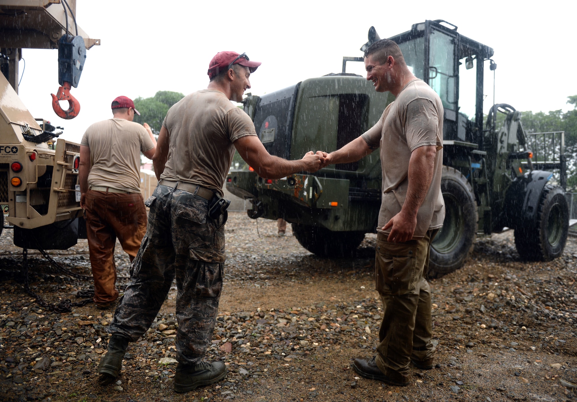 U.S. Air Force Senior Airman Charles Ballou (left) fist bumps U.S. Air Force Staff Sgt. Zacharia Blower, both 823rd Expeditionary RED HORSE Squadron pavements and construction equipment operators, at the well site located in the village of Honduras Aguan near Trujillo, Honduras, June 25, 2015. The well is one of multiple projects going on in and around Trujillo as part of NEW HORIZONS Honduras 2015 training exercise. NEW HORIZONS was launched in the 1980s and is an annual joint humanitarian assistance exercise that U.S. Southern Command conducts with a partner nation in Central America, South America or the Caribbean. The exercise improves joint training readiness of U.S. and partner nation civil engineers, medical professionals and support personnel through humanitarian assistance activities. (U.S. Air Force photo by Capt. David J. Murphy/Released)