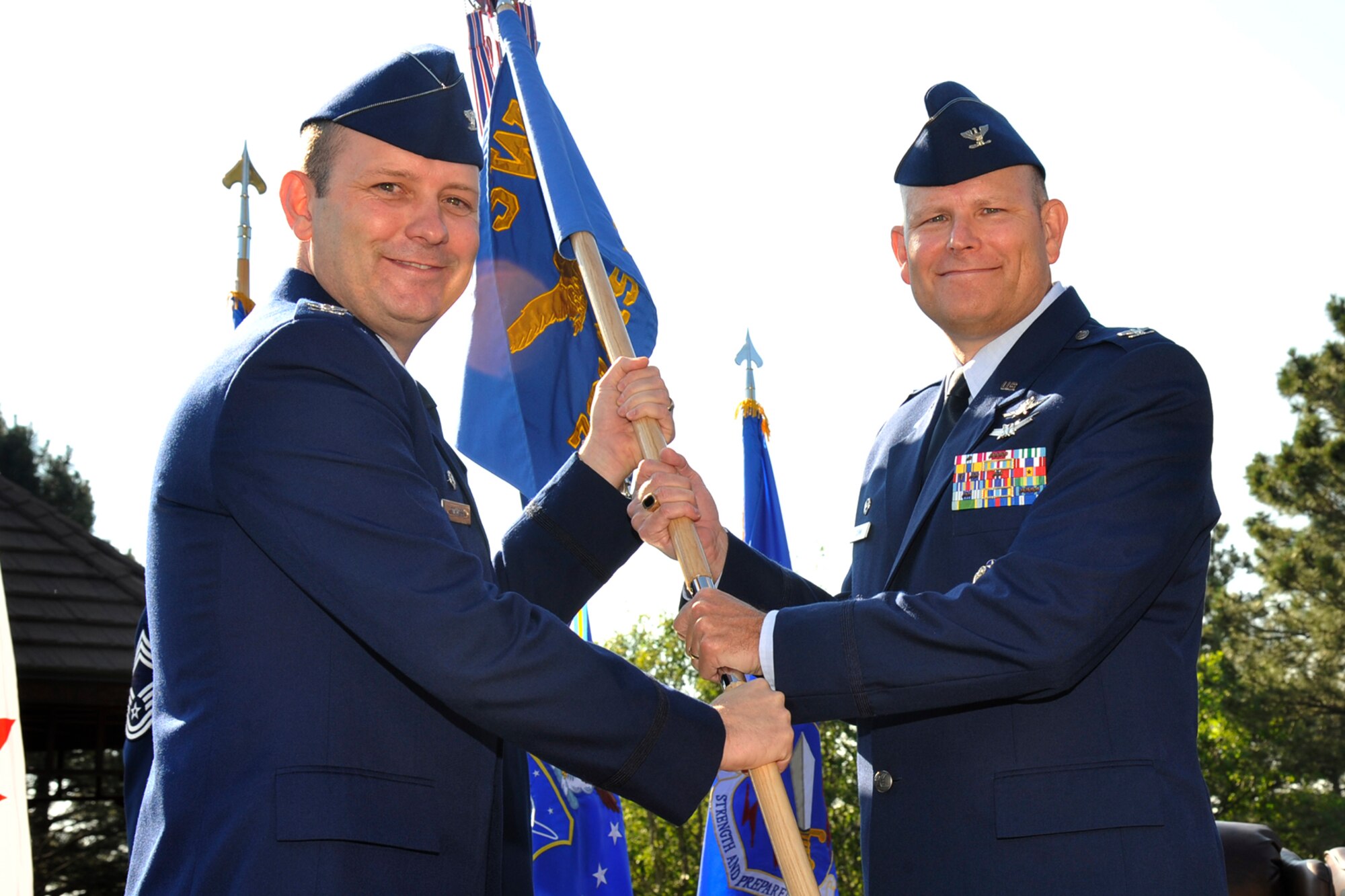 Col. Douglas A. Schiess, (left) 21st Space Wing commander, passes the 721st Mission Support Group guidon to Col. Gary L. Cornn Jr., incoming 721st MSG commander, during a change of command ceremony June 26, 2015. Cornn previously served as deputy director, Joint Information Environment Technical Synchronization Office, Defense Information Systems Agency, Fort Meade, Maryland, prior to assuming command of Cheyenne Mountain Air Force Station. (U.S. Air Force photo by Robb Lingley)