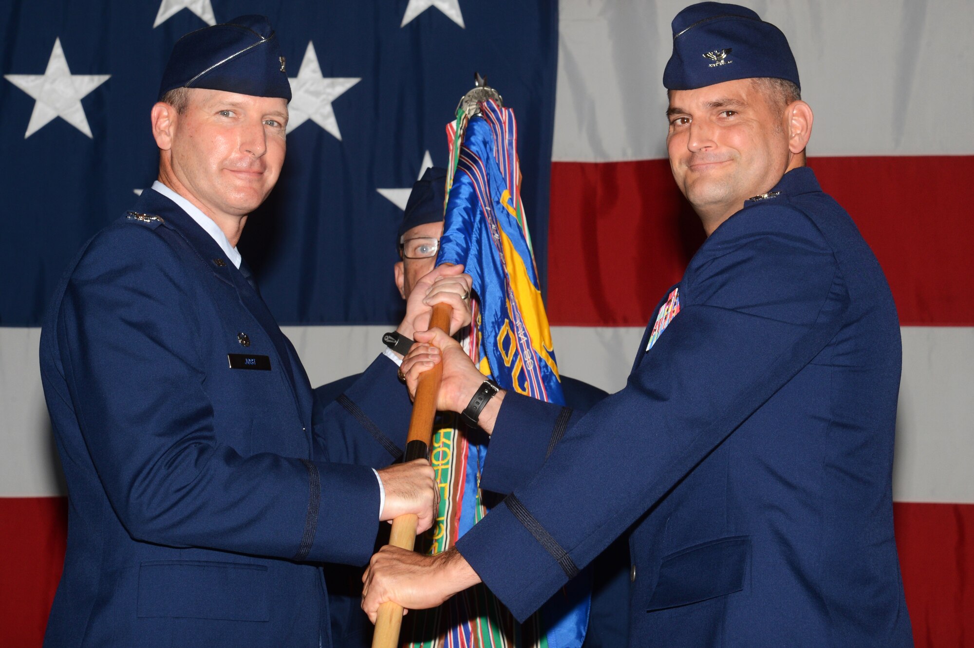U.S. Air Force Col. Douglas Thies, 20th Operations Group commander (right), receives the unit guidon from Col. Stephen Jost, 20th Fighter Wing commander, during the 20th OG change of command ceremony at Shaw Air Force Base, S.C., June 26, 2015. By accepting the guidon as a symbolic gesture of leadership, Thies became the 20th OG commander. (U.S. Air Force photo by Senior Airman Jonathan Bass/Released)