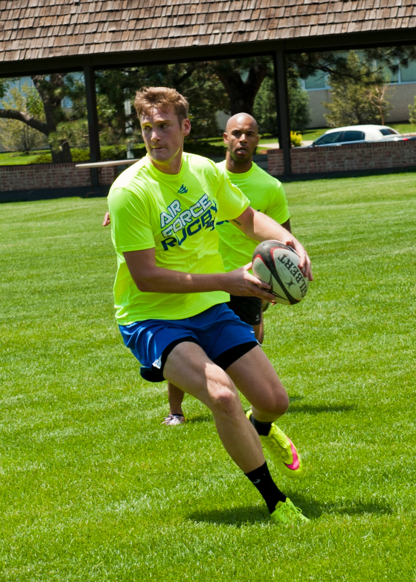 PETERSON AIR FORCE BASE, Colo. – A member of the Rugby Team looks to another teammate as he maneuvers during a team practice at Patriot Park on June 25, 2015. The team members are from across the Air Force and were at Pete to practice together for an upcoming civilian tournament in Denver. (U.S. Air Force photo by Airman 1st Class Rose Gudex)