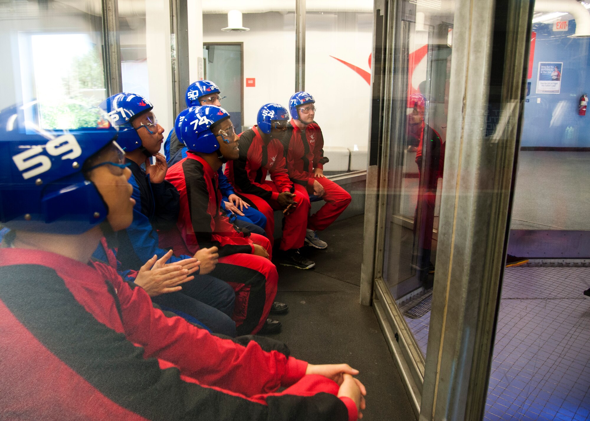 DENVER, Colo. – Members of Peterson Air Force Base wait for their turn to fly in the wind tunnel at IFly Indoor Skydiving for a Peterson Chapel retreat, June 19, 2015. Members of Peterson Air Force Base watch as one of the IFly World instructors fly around in the wind tunnel during a Peterson Chapel event, June 19, 2015. Peterson leadership picked their top performers to participate in a day retreat to indoor skydive, eat lunch and discuss the stress of military life and resources available. (U.S. Air Force photo by Senior Airman Tiffany DeNault)