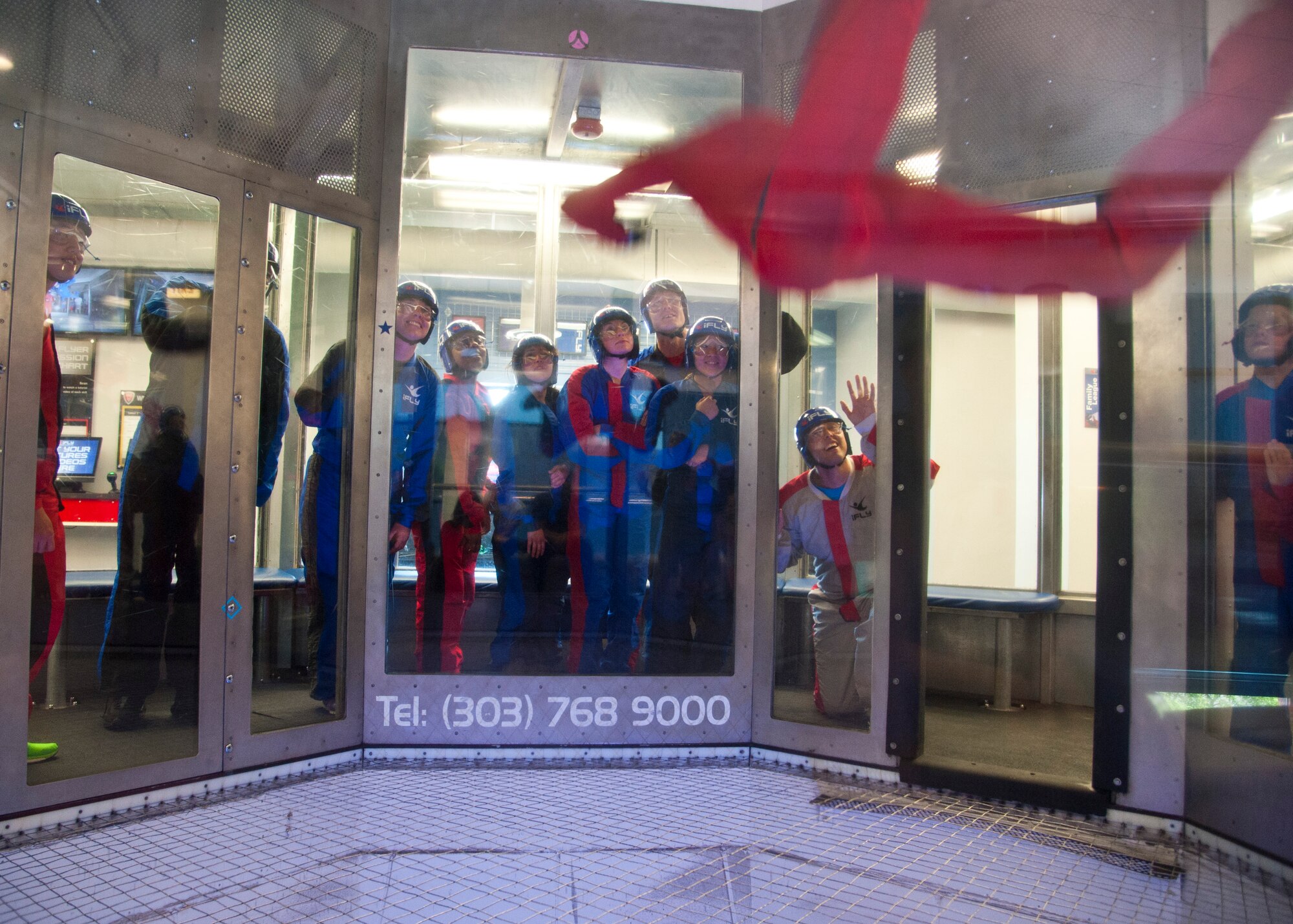 DENVER, Colo. – Members of Peterson Air Force Base watch as one of the IFly World instructors fly around in the wind tunnel during a Peterson Chapel event, June 19, 2015. Peterson leadership picked their top performers to participate in a day retreat to indoor skydive, eat lunch and discuss the stress of military life and resources available. (U.S. Air Force photo by Senior Airman Tiffany DeNault)