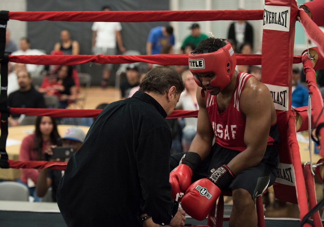 Senior Airman Martin E. Bills III, right, 366th Security Forces Squadron response force leader, listens to his coach's advice after a difficult second round during his fight at the Sorenson Center in Salt Lake City, March 28, 2015. Bills explained he exhausted himself in the first round of the fight and ran out of energy by the third round. He didn't let himself give up though; he expressed his family drives him to push forward despite the opposition. (U.S. Air Force photo by Airman 1st Class Jeremy L. Mosier/Released)