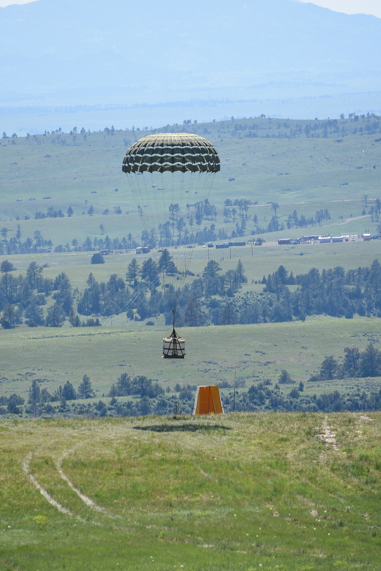 An aircrew assigned to the 153rd Airlift Wing, Wyoming Air National Guard drops a Container Delivery System (CDS) bundle from a C-130H Hercules aircraft from about 5,000 feet above ground during Joint Precision Airdrop Delivery System (JPADS) training June 27, 2015, at the North Training Area, Camp Guernsey Joint Training Center, Wyo. The aircrew delivered the CDS bundle within feet of their intended target. (U.S. Air National Guard photo by Master Sgt. Charles Delano)
