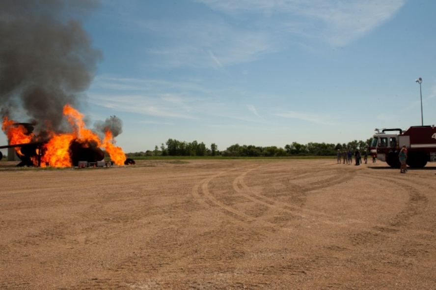 Airmen from the 5th Civil Engineer Squadron prepare to put out a live fire during an exercise at Minot Air Force Base, N.D., June 26, 2015. The 5th CES performed this exercise for retired Minot firefighters who held a reunion at the CE fire station. (U.S. Air Force photo/Airman 1st Class Christian Sullivan)