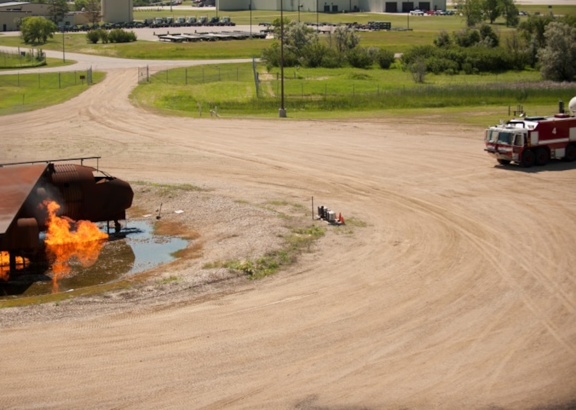 The 5th Civil Engineer Squadron performed a controlled live fire, in which an aircraft model is set on fire and responders extinguish the fire, for retired Minot firemen at Minot Air Force Base, N.D., June 26, 2015. The Base held a firefighter reunion to honor former firefighters and to show them what capabilities Minot firemen have. (U.S. Air Force photo/Airman 1st Class Christian Sullivan)