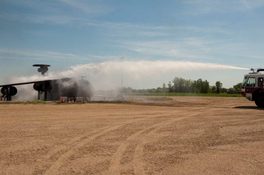 Airmen from the 5th Civil Engineer Squadron extinguish a live fire during an exercise at Minot Air Force Base, N.D., June 26, 2015. The base held a firefighter reunion to honor former firefighters and to show them what capabilities Minot firemen have. (U.S. Air Force photo/Airman 1st Class Christian Sullivan)