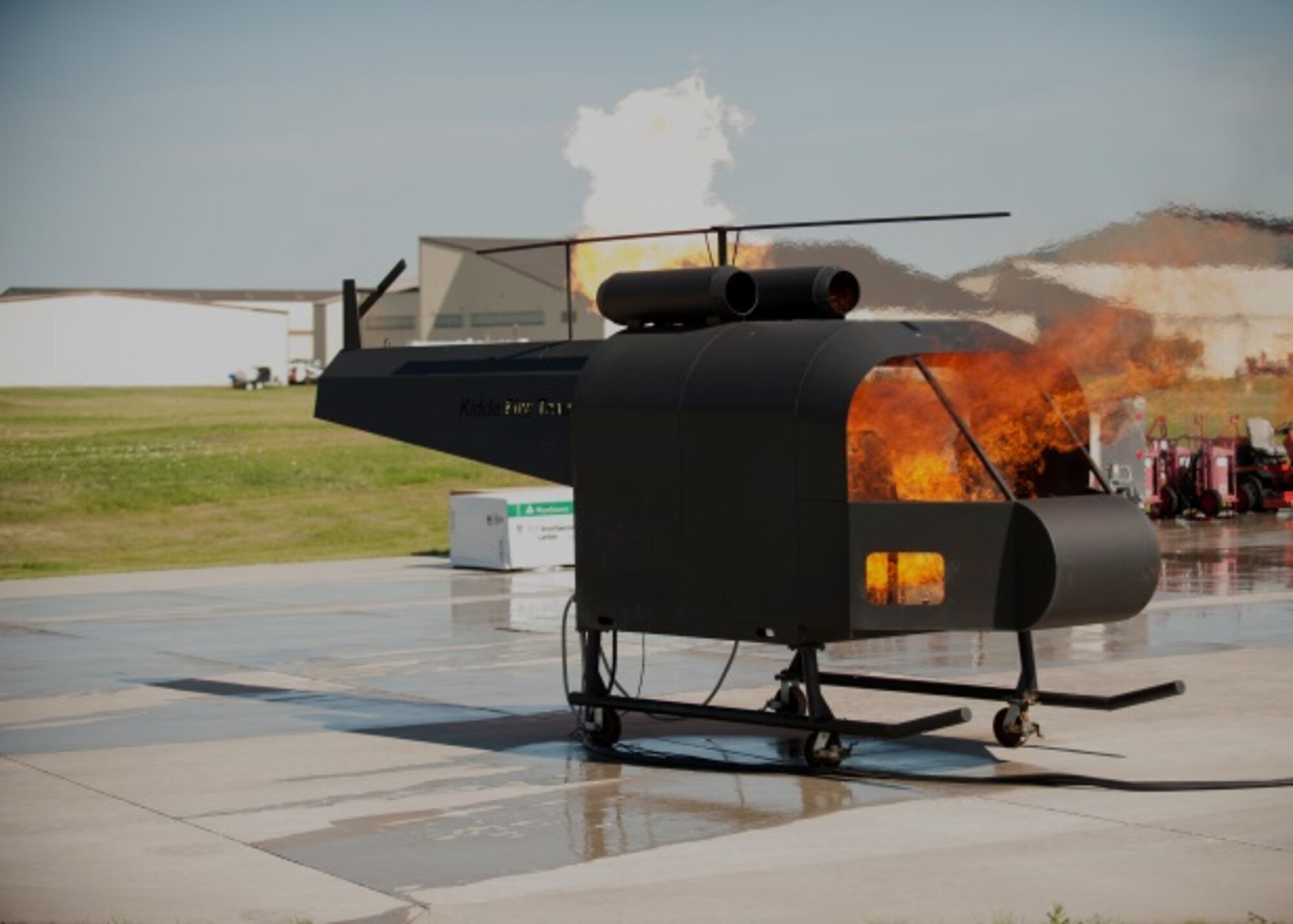 The 5th Civil Engineer Squadron sets fire to its new model helicopter, which is used for live fire exercises at Minot Air Force Base, N.D., June 26, 2015. Live fire exercises help CE Airmen test their response skills in emergency situations. (U.S. Air Force photo/Airman 1st Class Christian Sullivan)