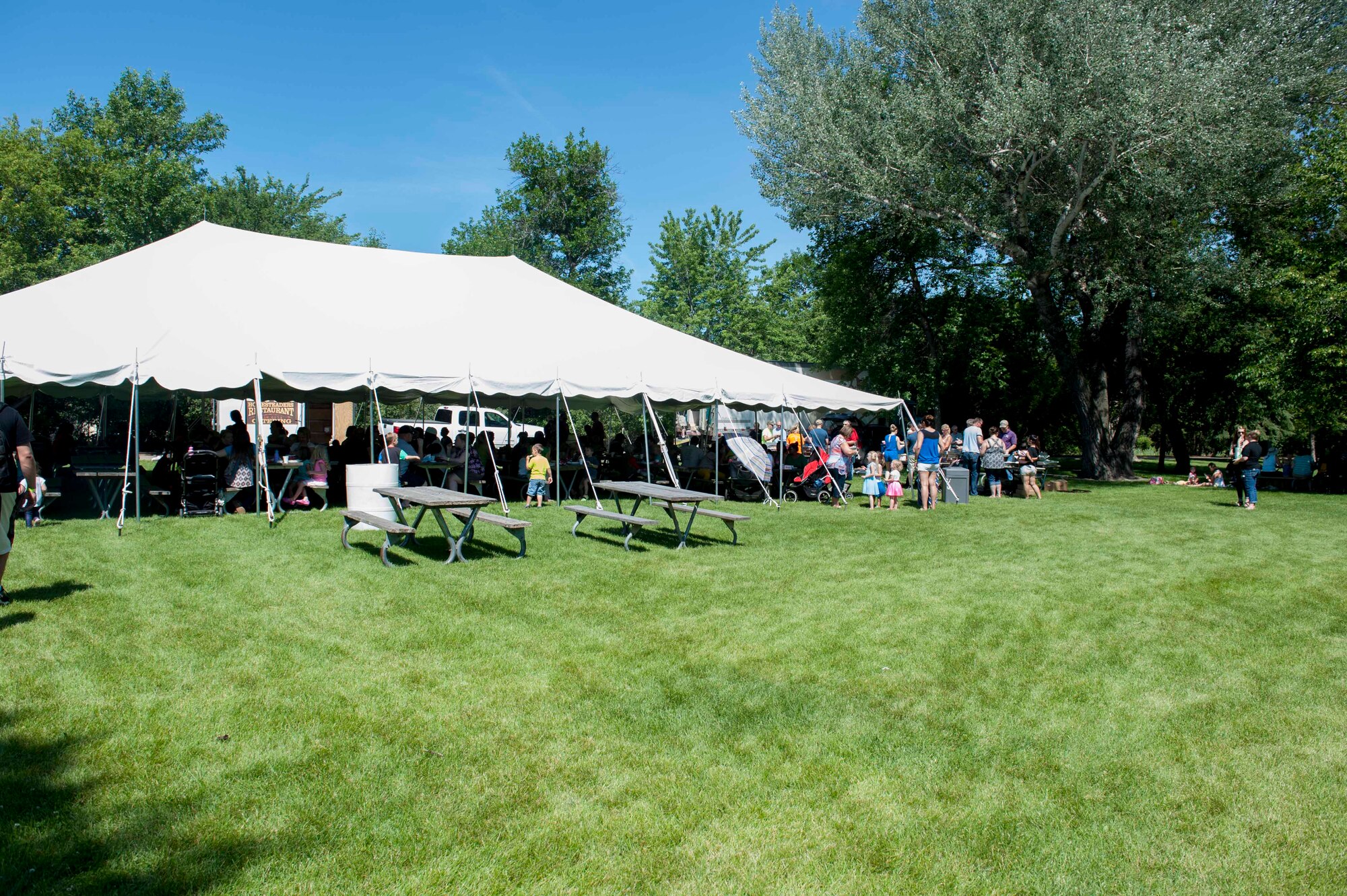 Airmen and their families eat under a pavilion during military appreciation day at the Roosevelt Park Zoo in Minot, N.D., June 26, 2015. Attendees were granted free entry into the zoo along with a free lunch. (U.S. Air Force photo/Airman 1st Class Sahara L. Fales)