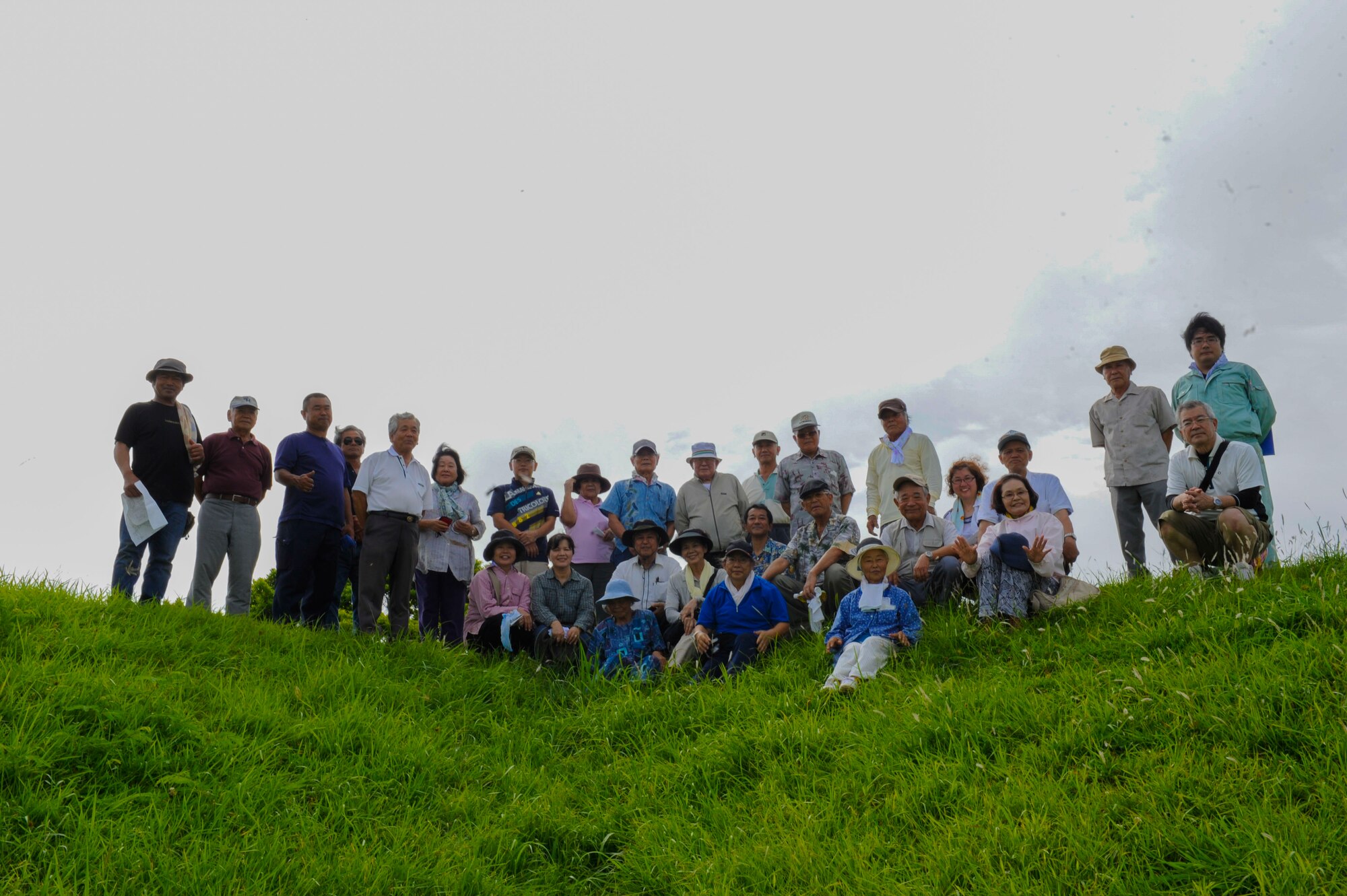 U.S. Air Force Airmen help local Okinawans up a trail during a sacred site tour on Kadena Air Base, Japan, June 28, 2015. The Okinawans shared their stories with the Airmen about their family history and experiences during World War II. (U.S. Air Force photo by Airman 1st Class Lynette Rolen)
