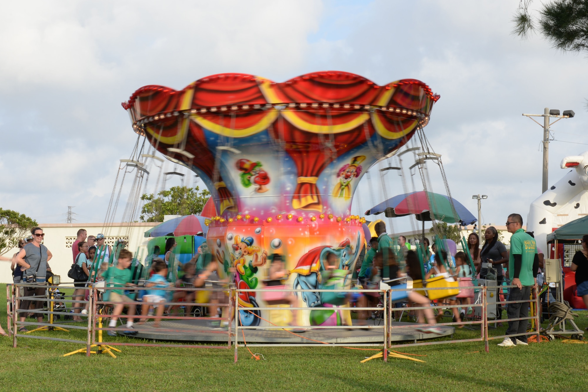 Members of Team Kadena and their families watch their children play on a carousel during the 18th Force Support Squadron’s Rockin’ the Block on Kadena Air Base, Japan, June 27, 2015. The event featured live music, crafts, food and prize drawings. Rockin’ the Block was open to Status of Forces Agreement personnel and their families in honor of the Fourth of July. (U.S. Air Force photo by Senior Airman Omari Bernard)