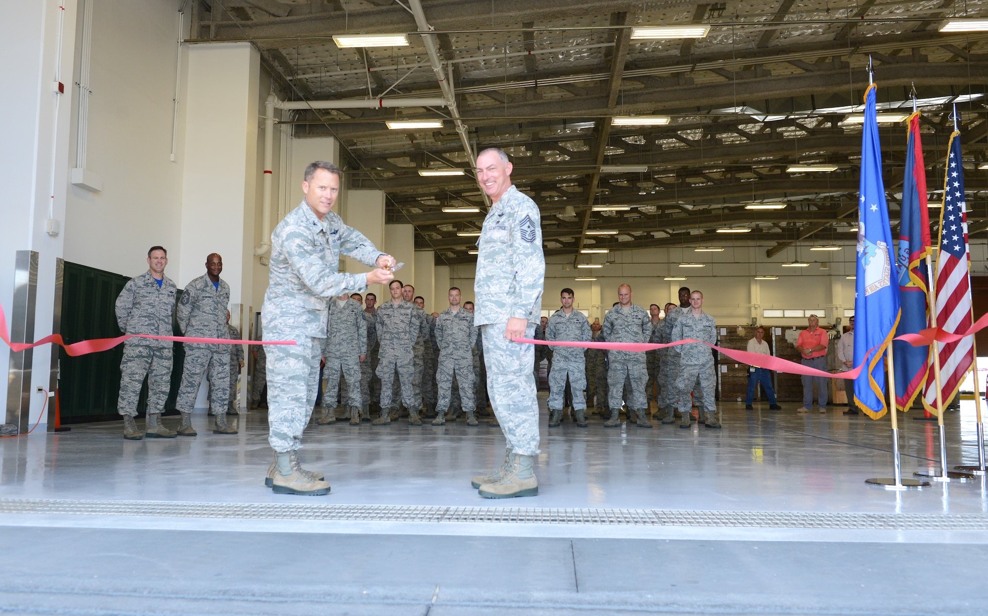 Col. Casey Eaton, 515th Air Mobility Operations commander, cuts the ribbon during the opening of the new air freight terminal June 26, 2015, at Andersen Air Force Base, Guam.  The new facility offers more working and storage space to enhance capabilities for the Pacific theater. (U.S. Air Force photo by Airman 1st Class Arielle Vasquez/Released)