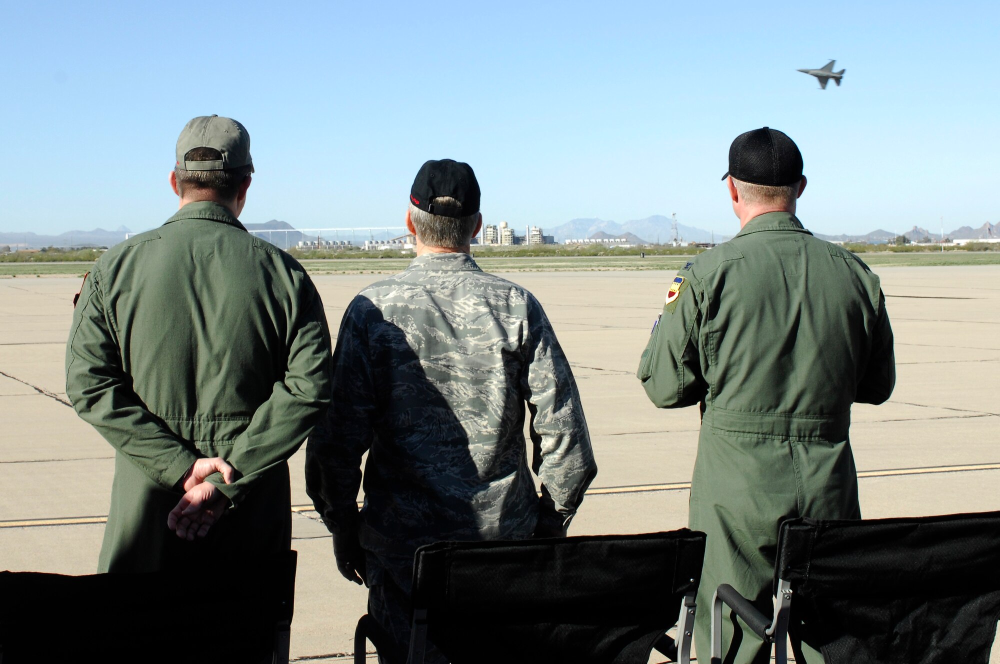 U.S. Air Force General Hawk Carlisle (center), Commander of Air Combat Command, observers an F-16 Fighting Falcon fly over during the Heritage Flight Training Conference at Davis-Monthan Air Force Base, Ariz., Feb, 27, 2015. Carlisle certified a Viper Demonstration Team pilot, allowing him to fly in future airshows.  (U.S. Air Force photo by Airmen 1st Class Cheyenne Morigeau/Released)