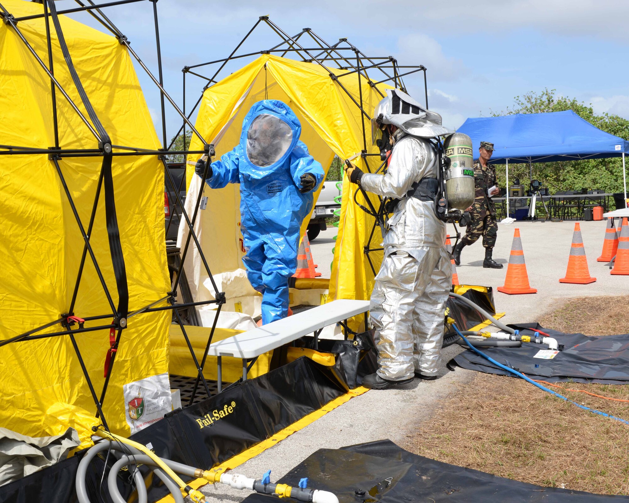 Members of the BioEnvironmental Engineering Flight demonstrate decontamination after being exposed to hazardous material during an exercise demonstration Feb. 27, 2015, at Andersen Air Force Base, Guam. The 36th CES Readiness and Emergency Management Flight hosted the visit and oversaw the chemical, biological, radiological, nuclear and explosive demonstration for our Philippine partners. (U.S. Air Force photo by Senior Airman Cierra Presentado/Released)