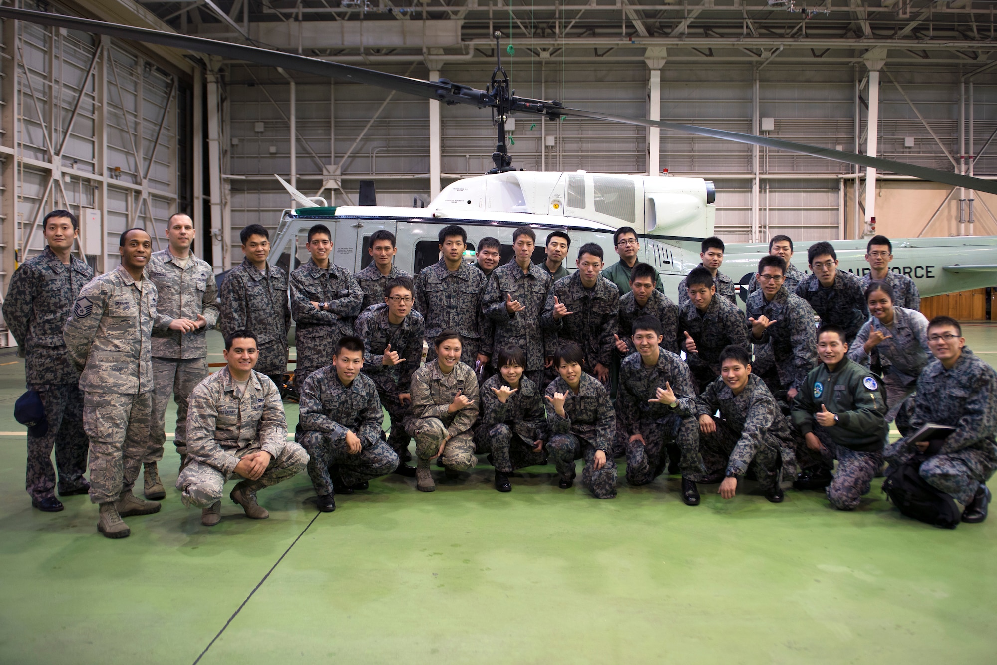 Members of the U.S. Air Force and Japan Air Self-Defense Force pose in front of a UH-1N Huey at Yokota Air Base, Japan, Feb. 25, 2015. By touring various maintenance facilities, these JASDF basic maintenance officer students gained insight into how an operational maintenance squadron functions on a daily basis. (U.S. Air Force photo by Airman 1st Class Delano Scott/Released)
