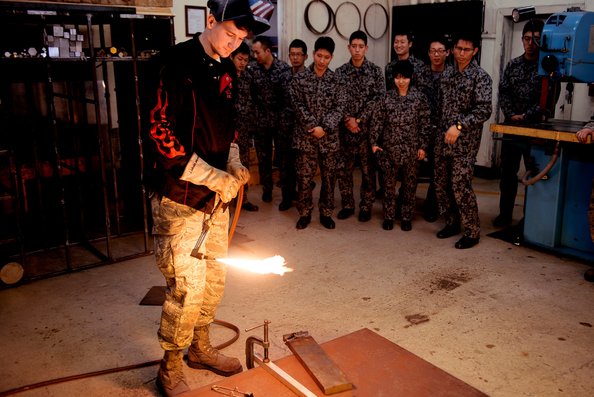 Senior Airman Justin Weeks, 374th Maintenance Squadron aircraft metals technology member, demonstrates soldering techniques to Japan Air Self-Defense Force basic maintenance officer students at Yokota Air Base, Japan, Feb. 25, 2015. The JASDF basic maintenance officer students toured the 374th MSG facilities to absorb the distinctions between U.S. and Japanese maintenance operations. (U.S. Air Force photo by Airman 1st Class Delano Scott/Released)